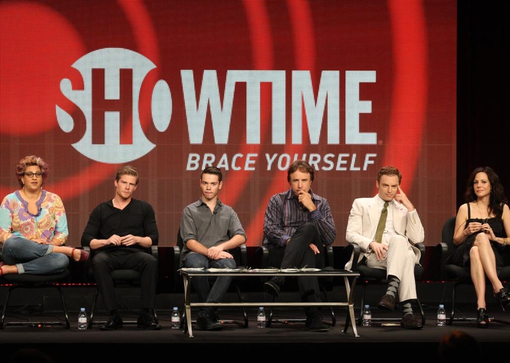 Weeds cast and crew speak on stage during the 2012 Summer Television Critics Association tour. The words Showtime, brace yourself, are projected behind them.