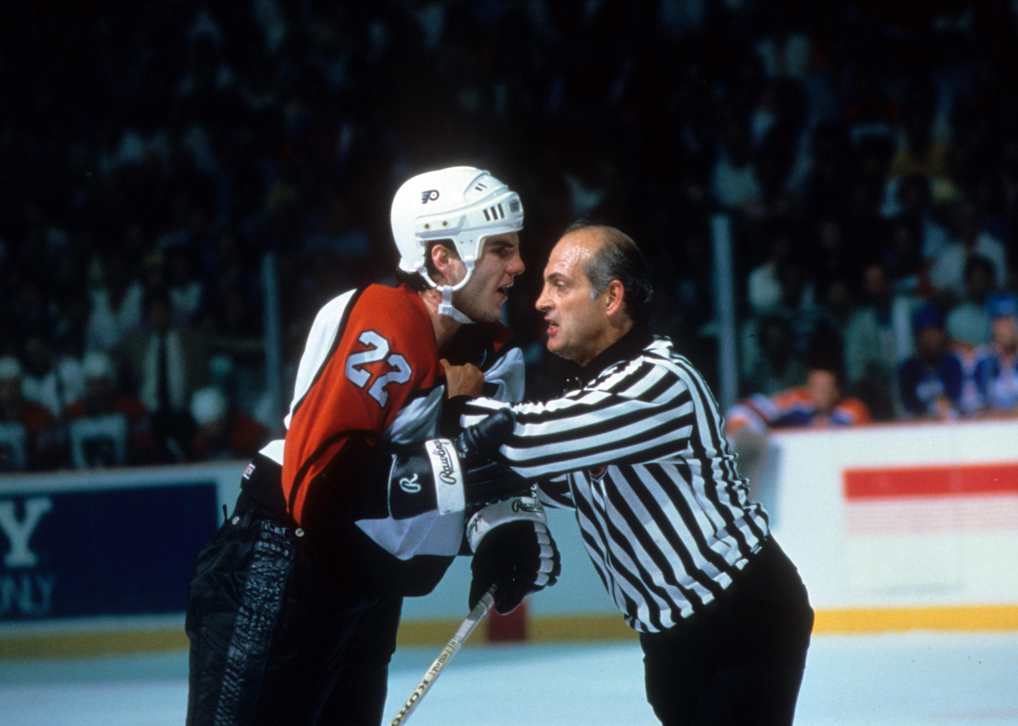 Rick Tocchet of the Philadelphia Flyers is restrained by a linesman/