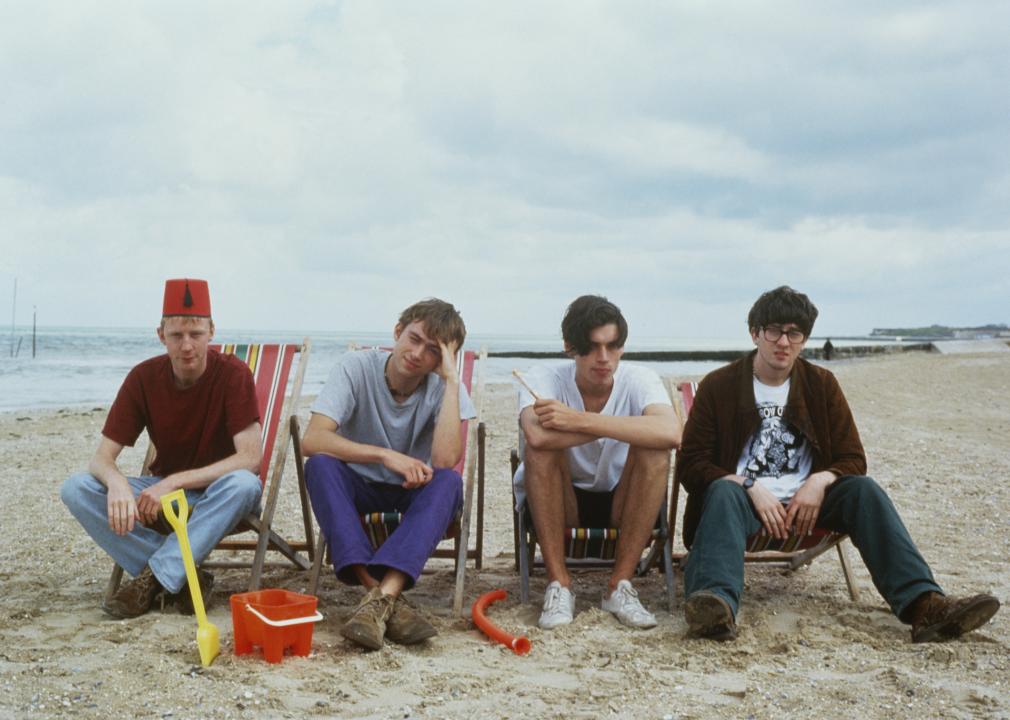 British band Blur sitting on a beach, circa 1996.