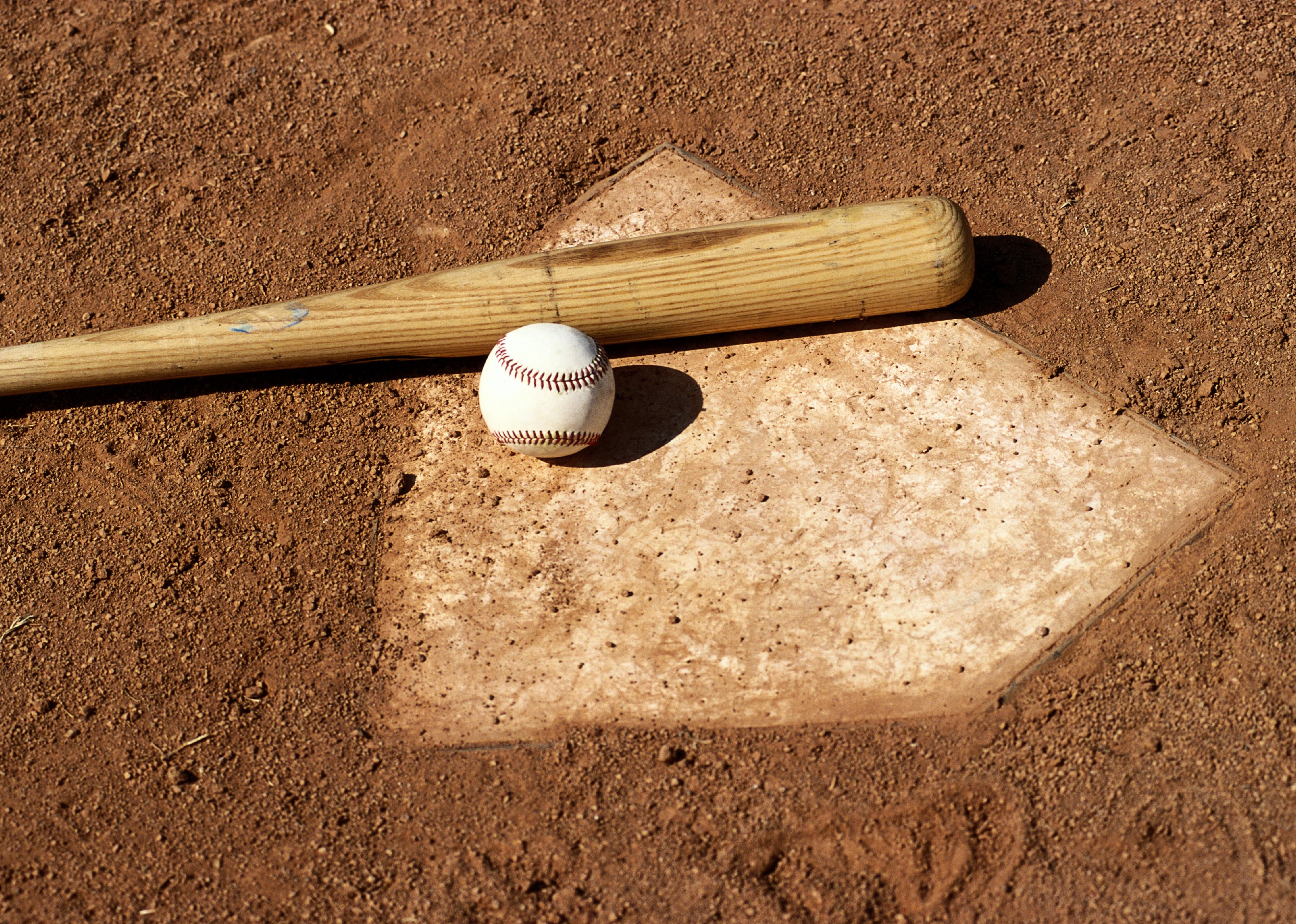 Baseball bat and ball on home plate.