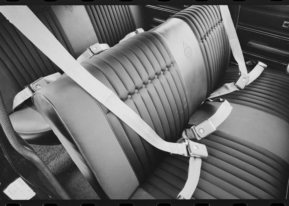 Interior of a vehicle, with all of the seat belts buckled, circa 1967.