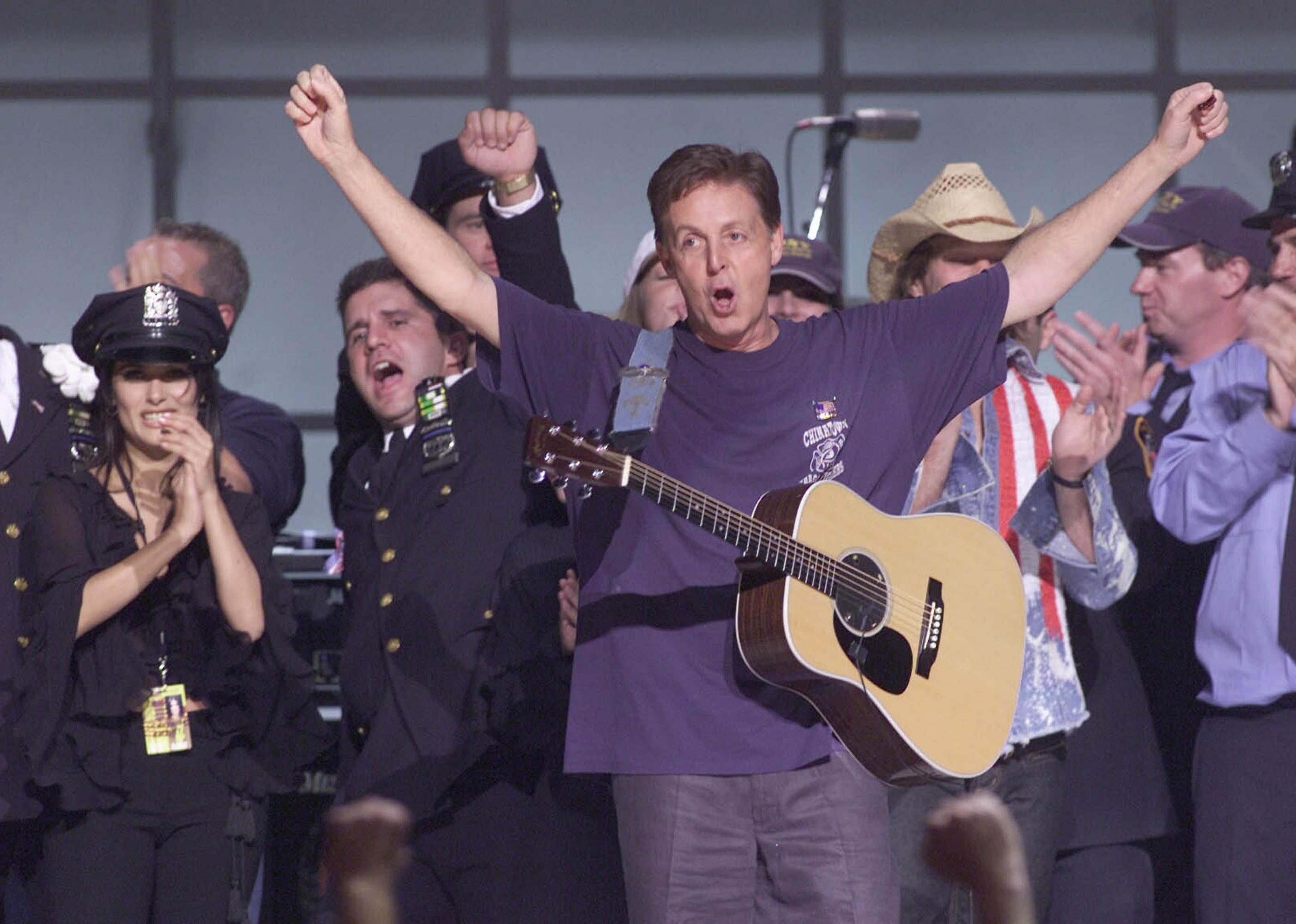 Paul McCartney performs on stage alongside other artists at The Concert for New York City.