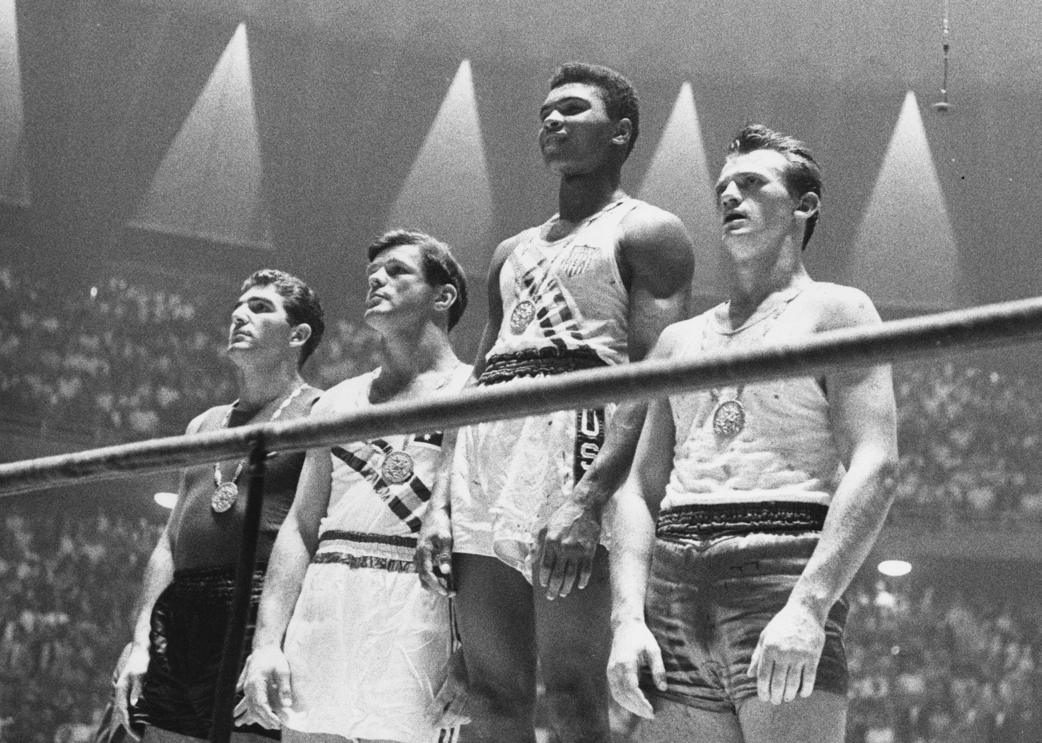 The winners of the 1960 Olympic medals for light heavyweight boxing on the winners' podium.