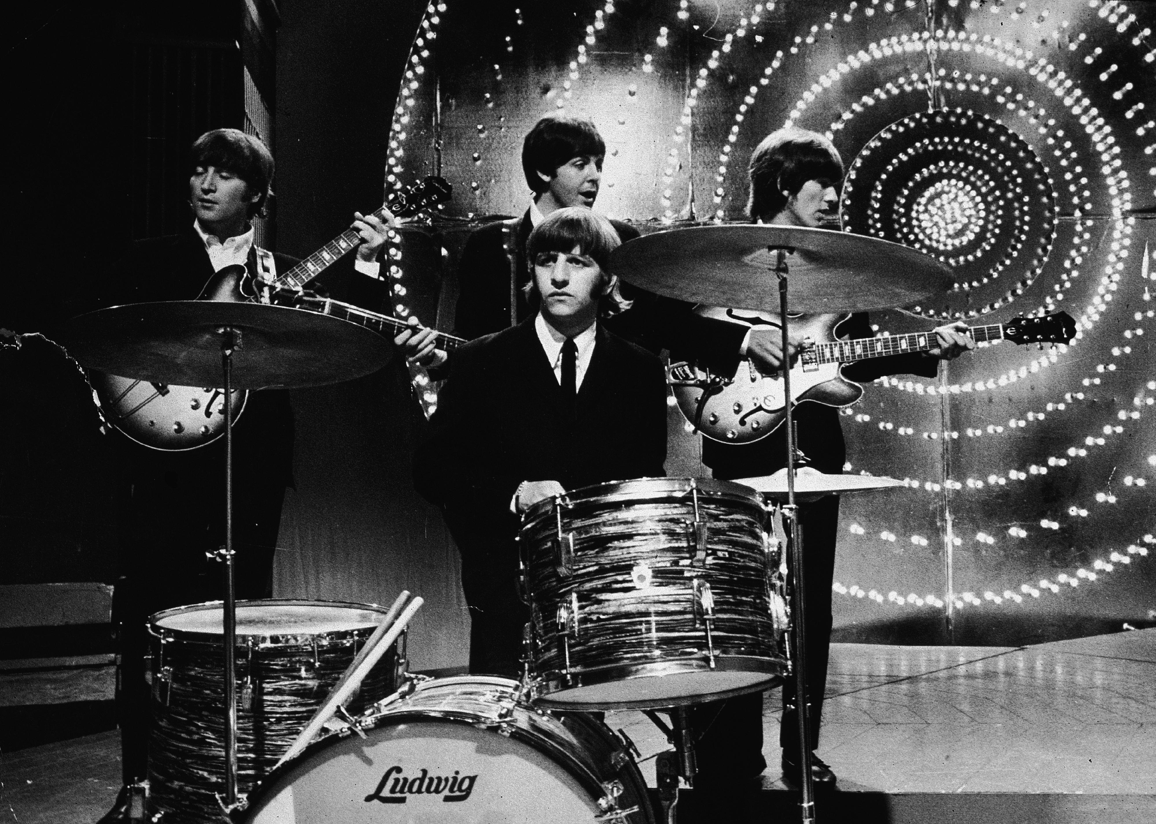 The Beatles performing onstage.