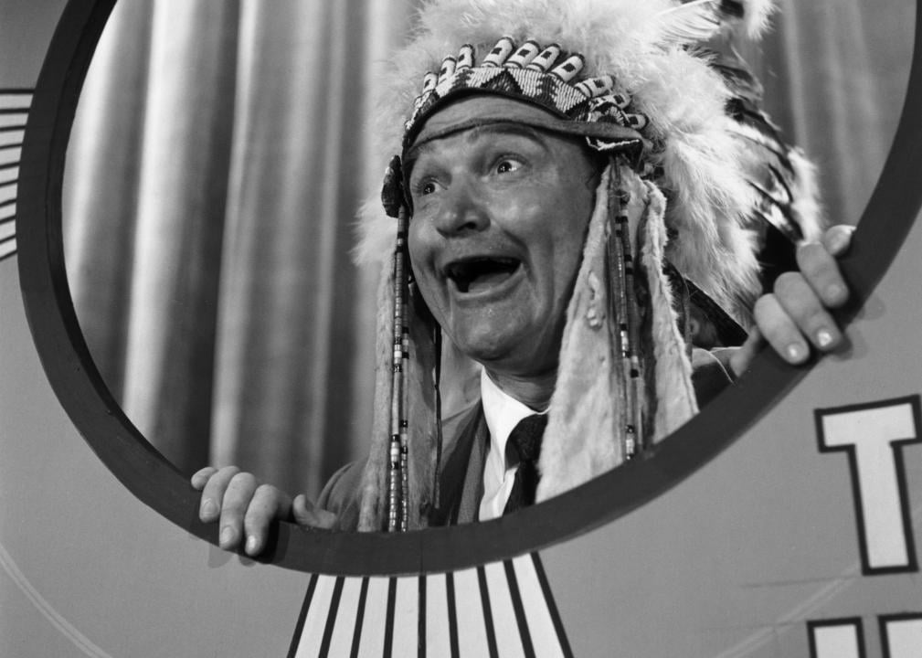 Red Skelton wearing an Indian headdress and sticking his head out of a prop on 'The Red Skelton Hour'