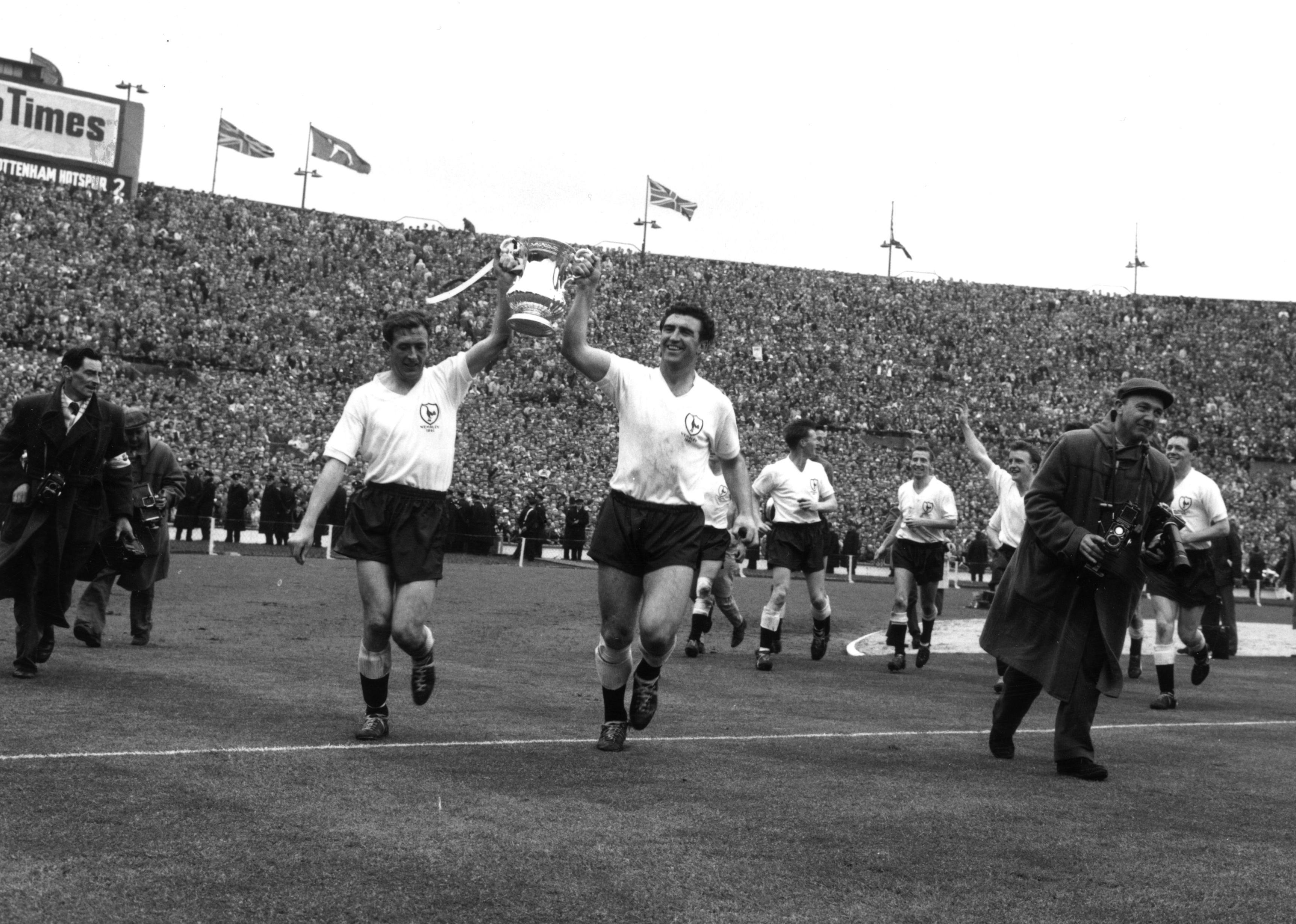 Tottenham Hotspur players carry the FA Cup trophy on a victory lap.