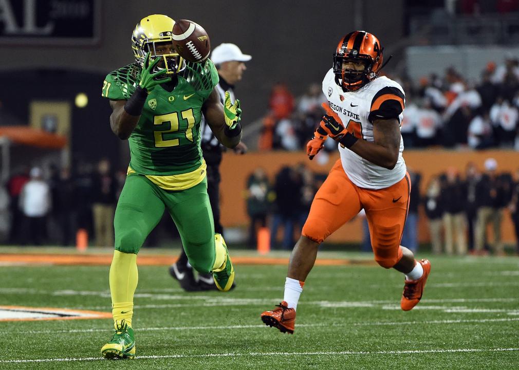 Running back Royce Freeman #21 of the Oregon Ducks juggles the ball as linebacker Jabral Johnson #44 of the Oregon State Beavers gives chase 