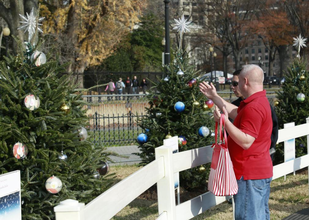 People wearing short sleeved shirts admire Christmas trees in Washington D.C.