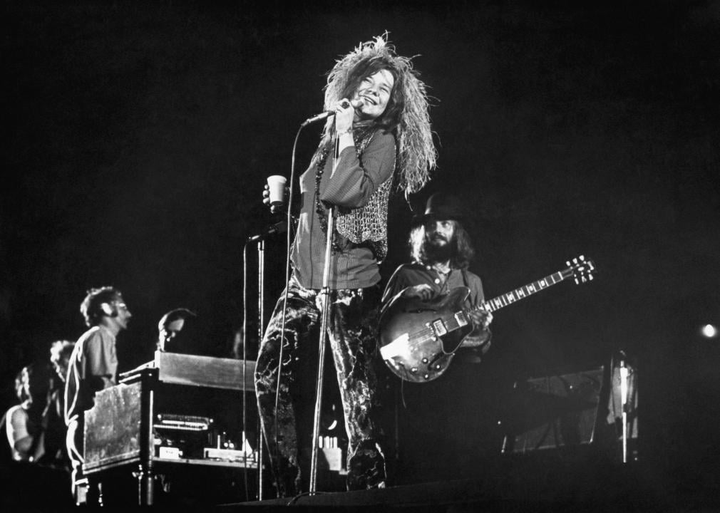 Janis Joplin performing onstage with band.
