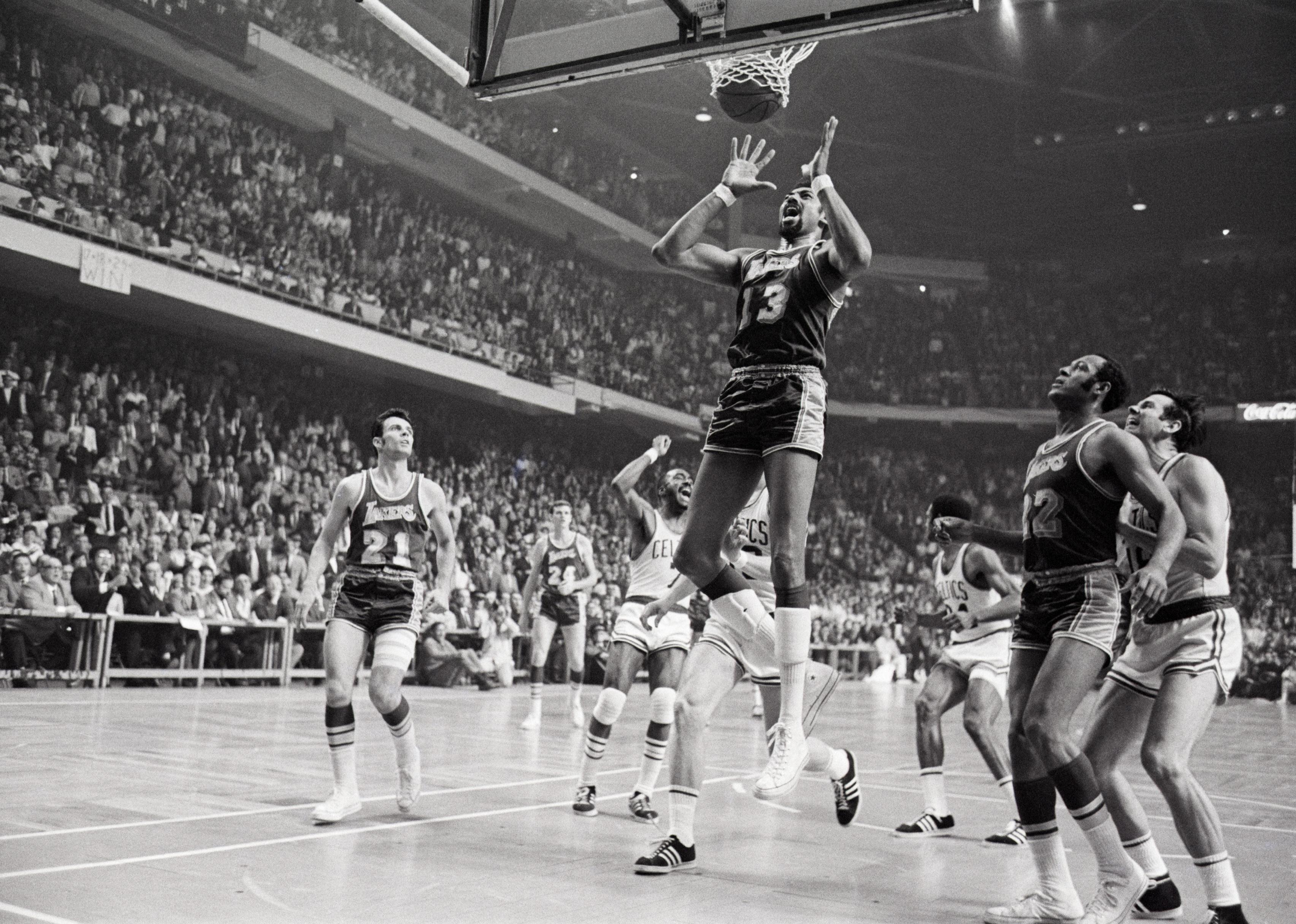 Wilt Chamberlain grimaces at Celtics' Sam Jones winning basket.