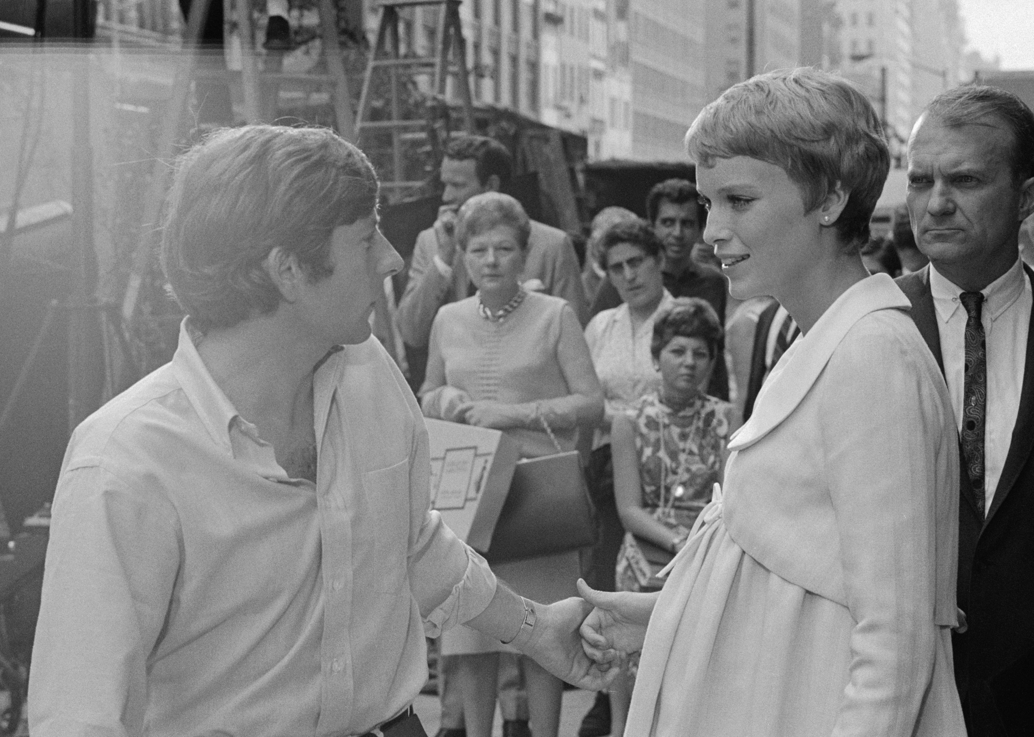  Director Roman Polanski outlines a scene for Mia Farrow, while a crowd watches.
