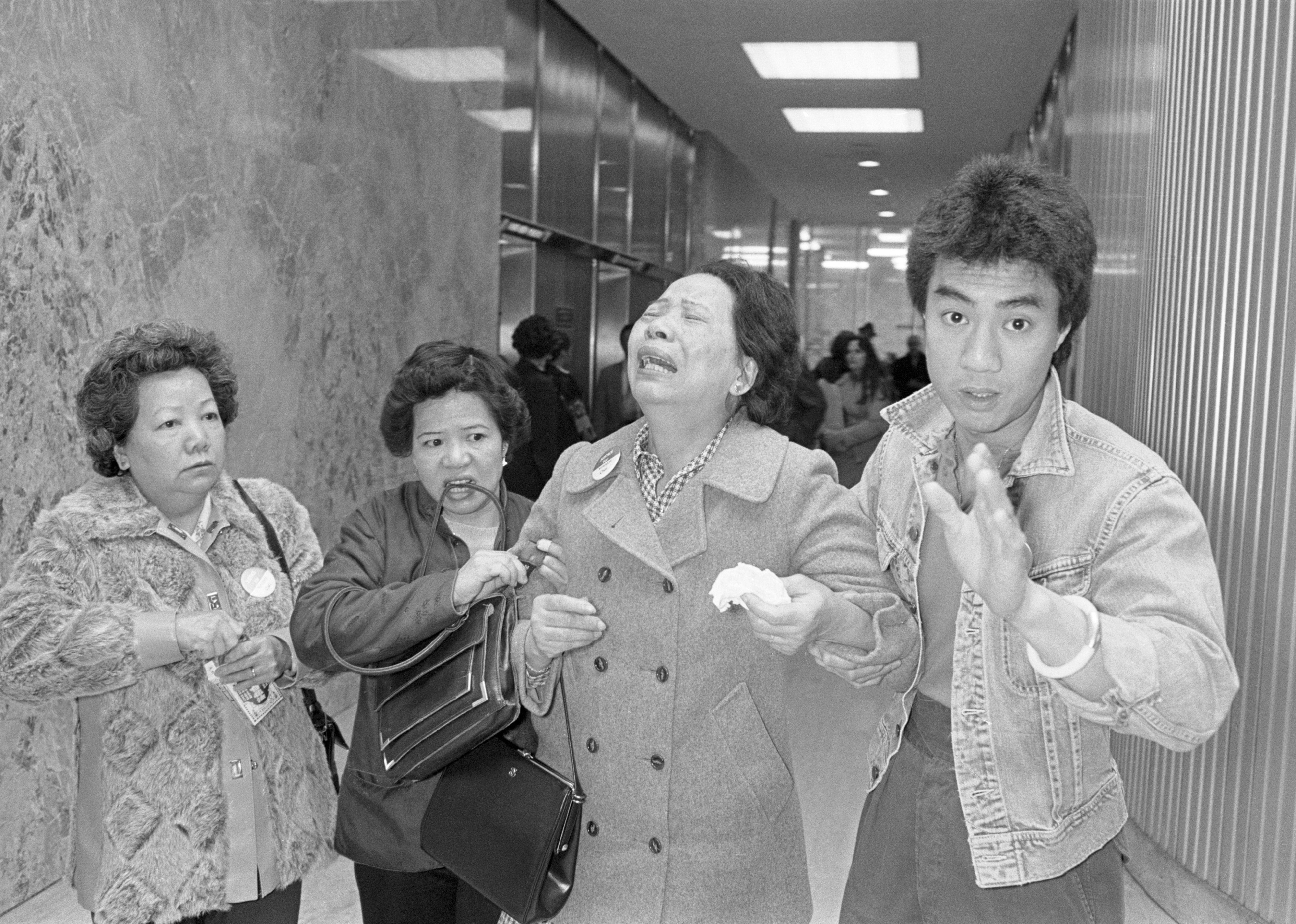 Lillie Chin, mother of Vincent Chin breaks down as a relative helps her walk while leaving Detroit's City County Building. 