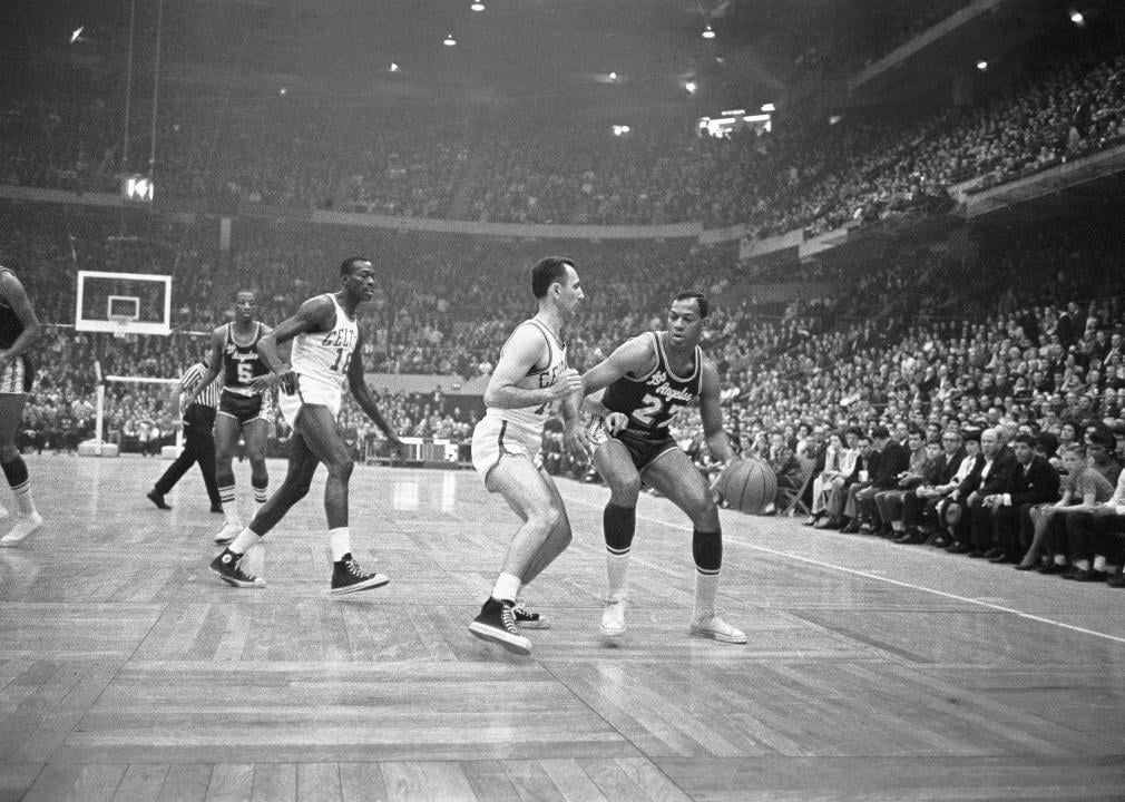 Elgin Baylor tries to maneuver the ball around Bob Cousy of the Boston Celtics