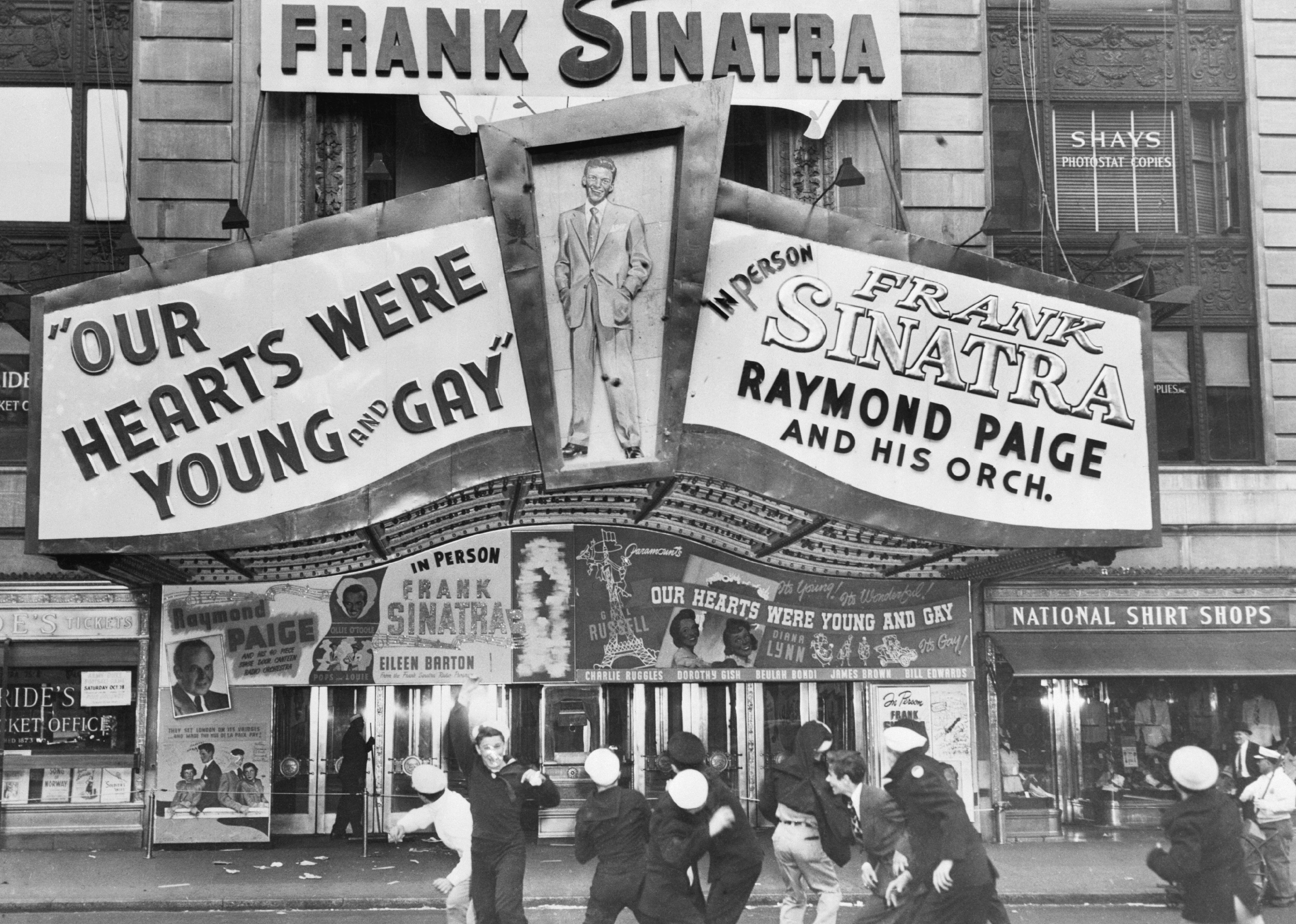 People Throwing Tomatoes at a Theater with Frank Sinatra sign.