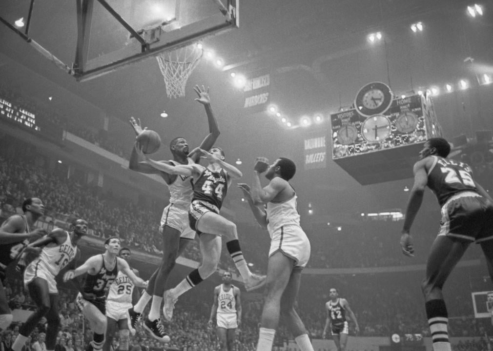 Jerry West is guarded closely as he goes in for a layup
