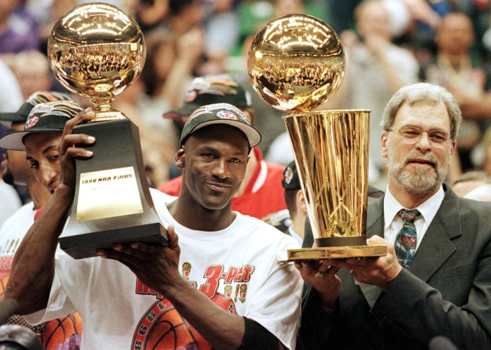 Michael Jordan and head coach Phil Jackson hold the Most Valuable Player trophy and the Larry O'Brian trophy.