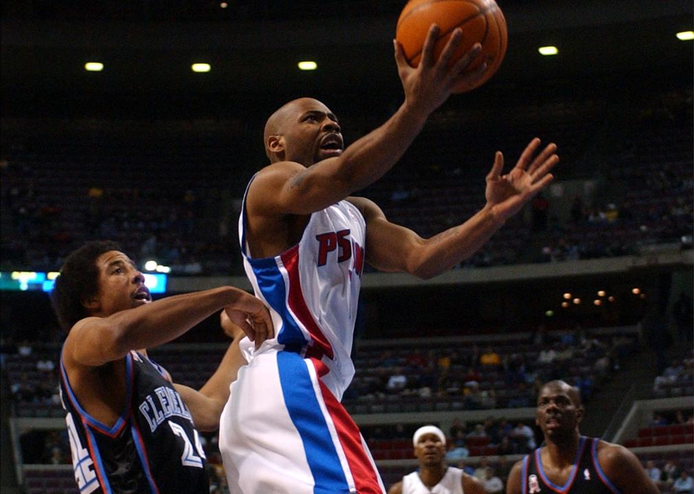 Detroit Pistons' Chucky Atkins puts up a shot in front of Cleveland Calaliers' Andre Miller.