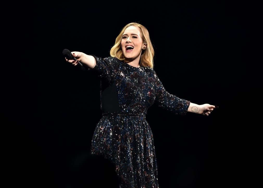 Adele performing onstage in sparkling black dress.