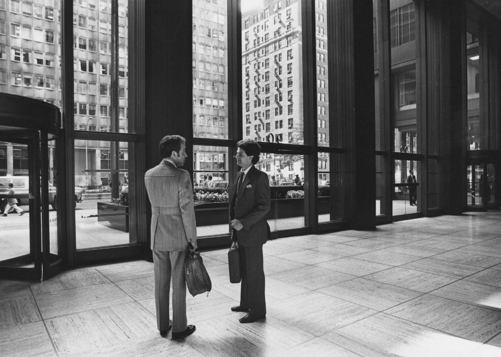 Two men talking in the reception area of a large building