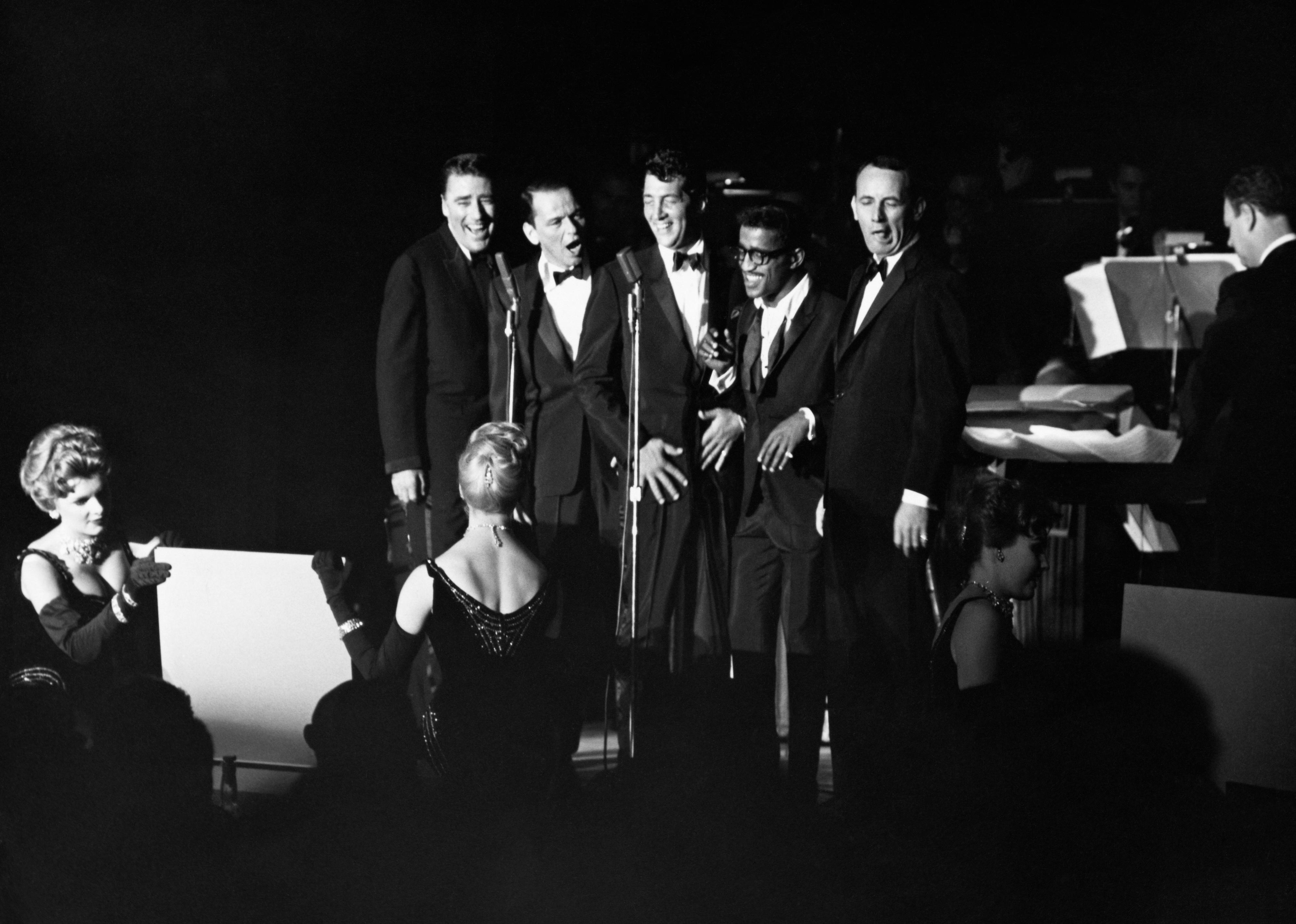 Peter Lawford, Frank Sinatra, Dean Martin, Sammy Davis Jr., and Joey Bishop performing. 