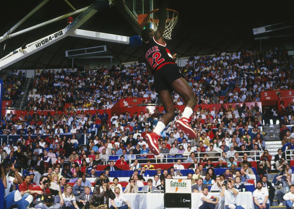 Clyde Drexler jumps through the air for a slam dunk 