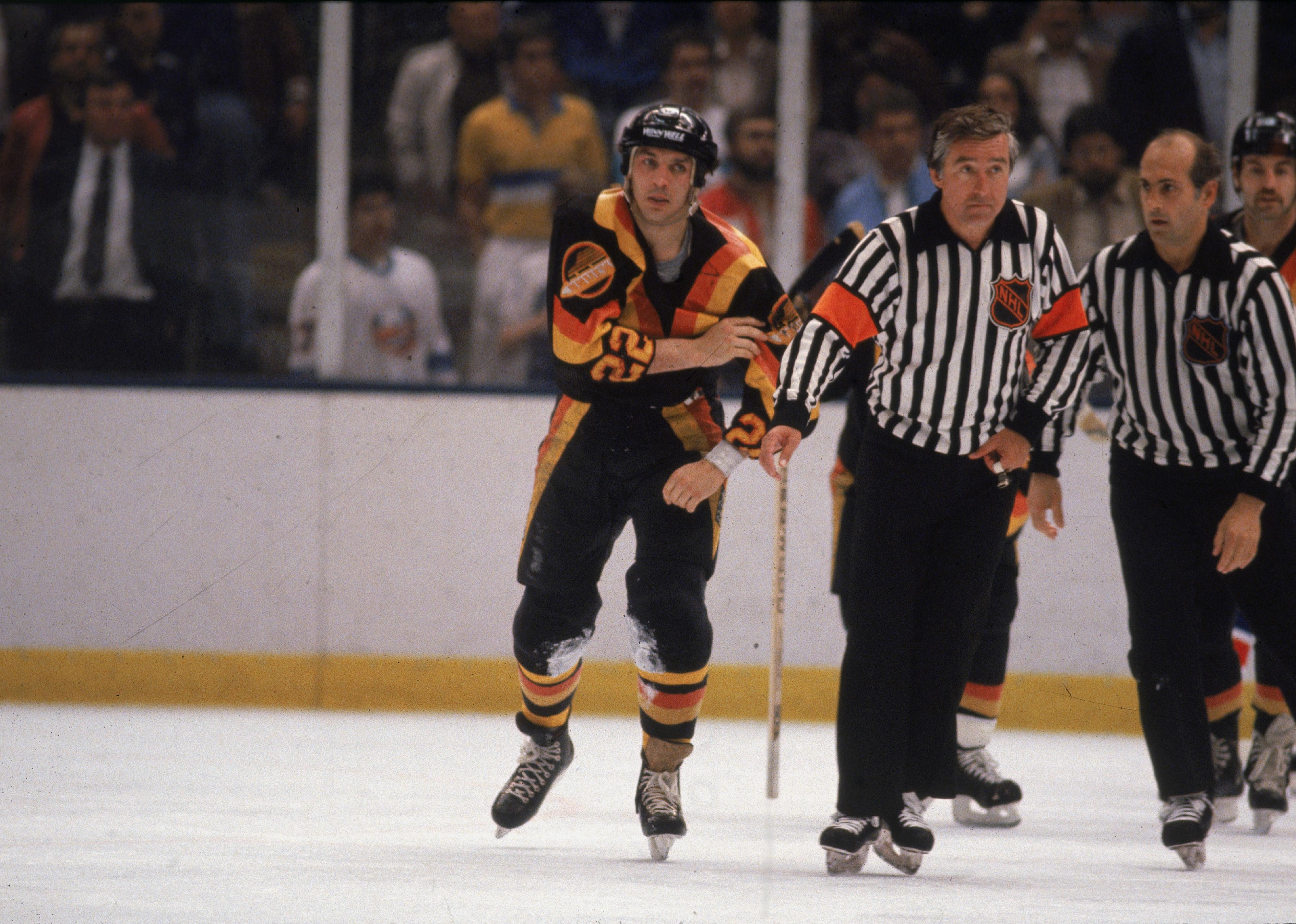 Dave 'Tiger' Williams is escorted of the ice by two officials.