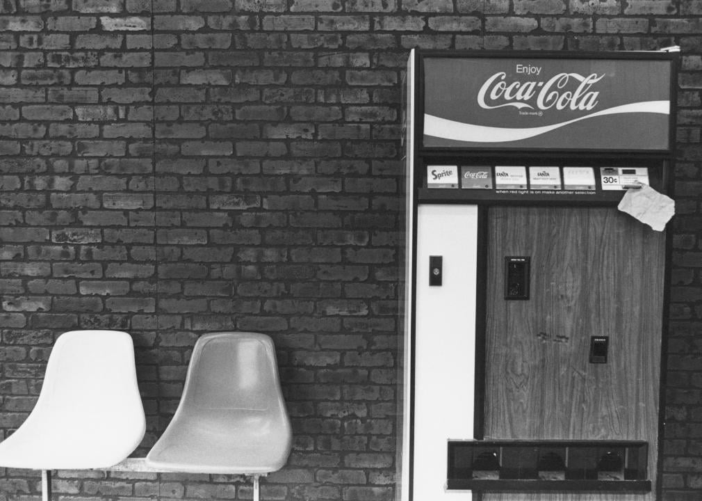 A vintage vending machine selling Coca-Cola and other soft drinks.