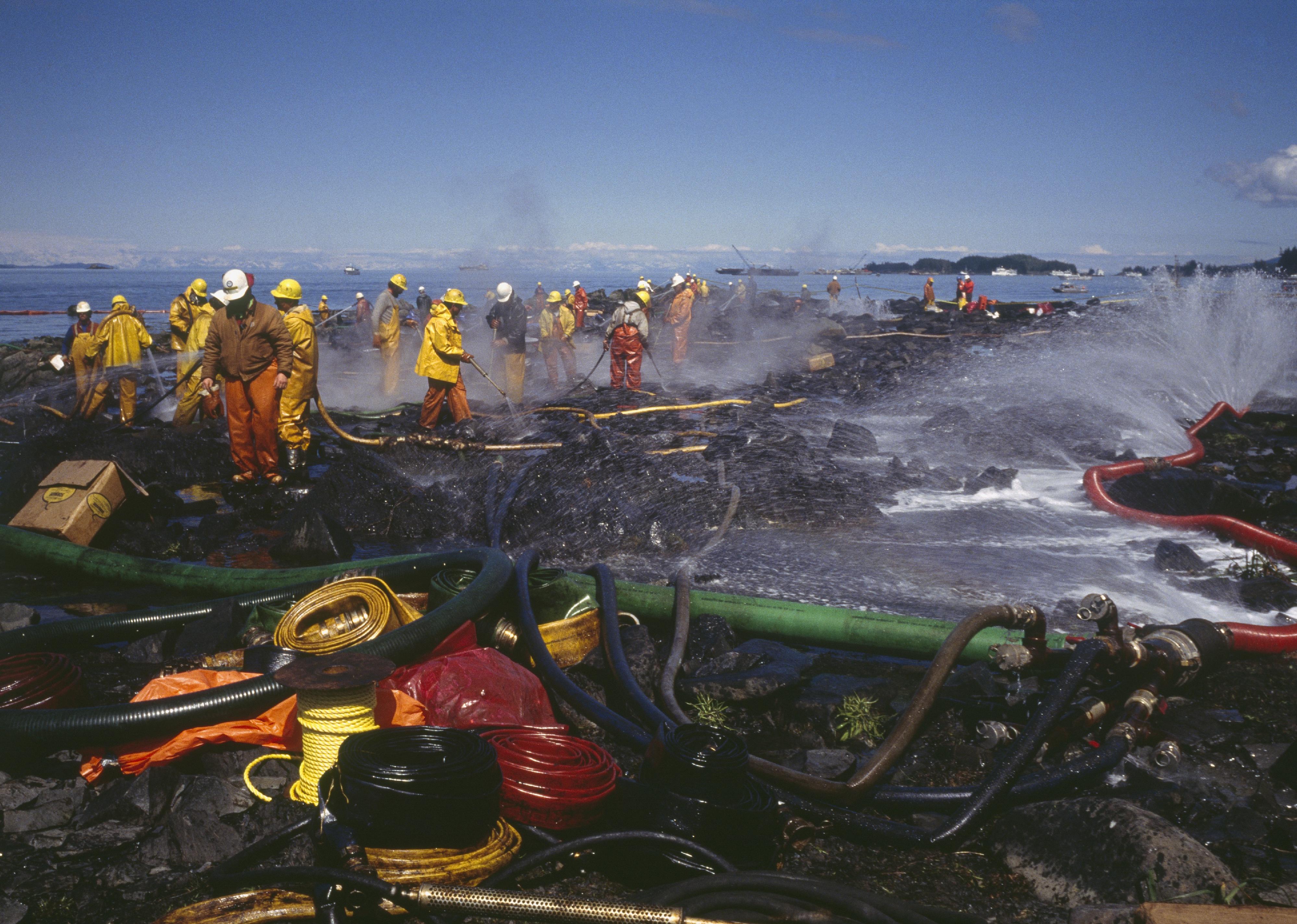 Teams of firefighters cleaning the Alaskan coast following the Exxon Valdez oil spill. 