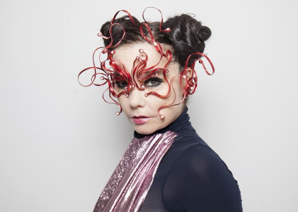 Portrait of Bjork wearing space buns and a futuristic red mask.