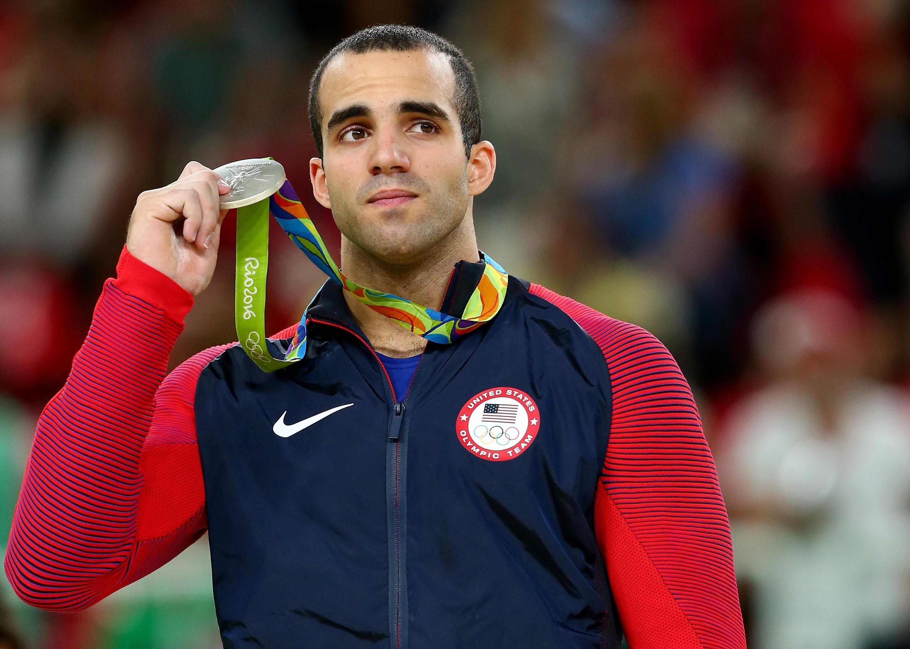 Danell Leyva celebrates on the podium at the medal ceremony. 