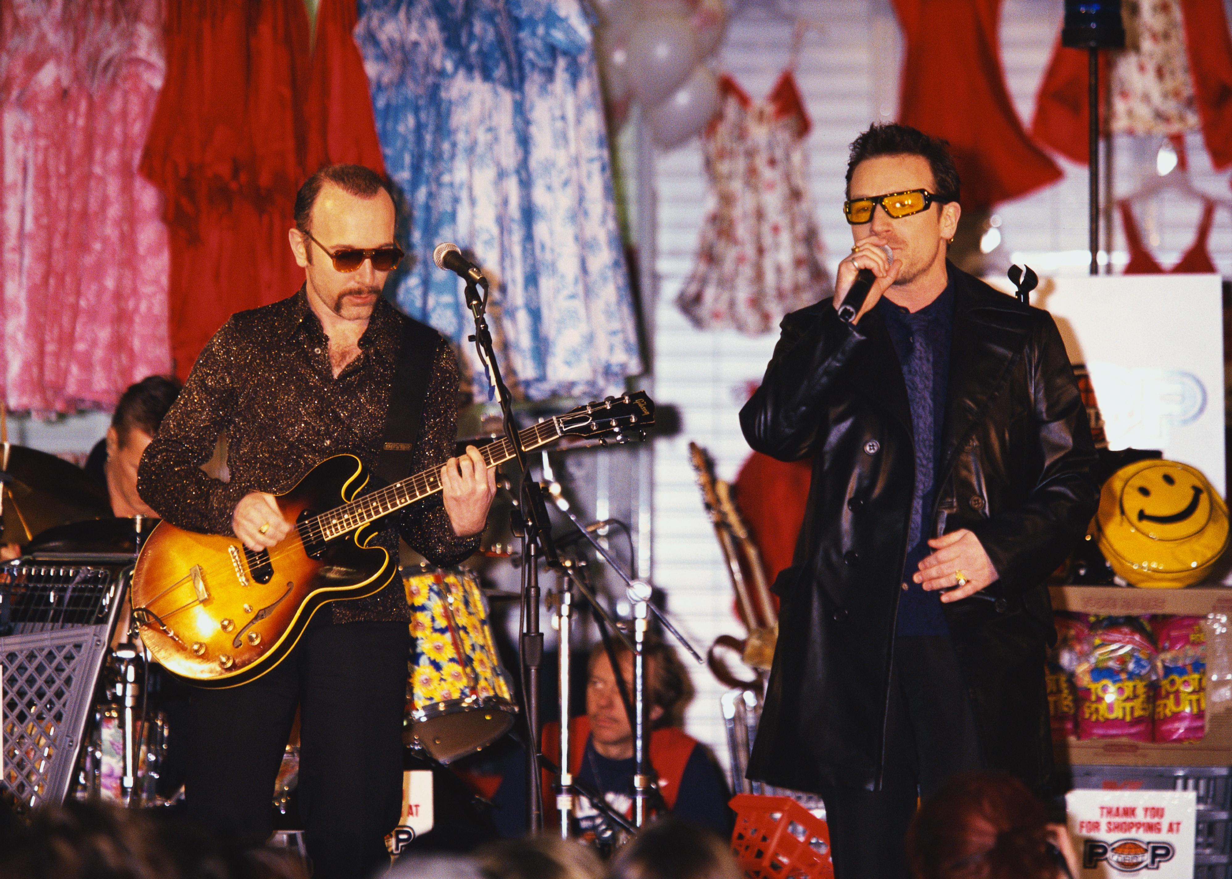 The Edge and Bono of U2 performing on stage.