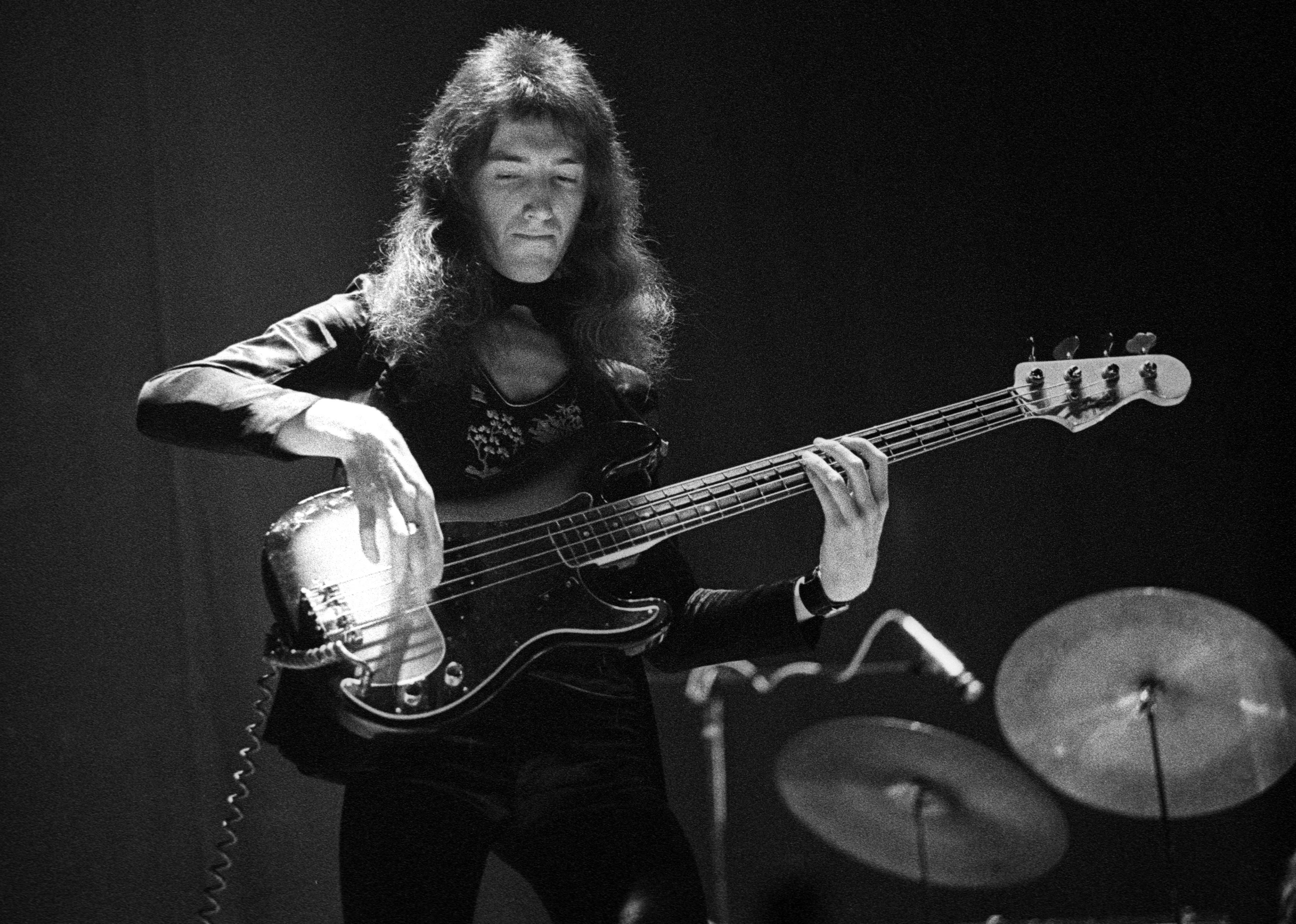 John Deacon of Queen performs on stage at the Rainbow Theatre in London.