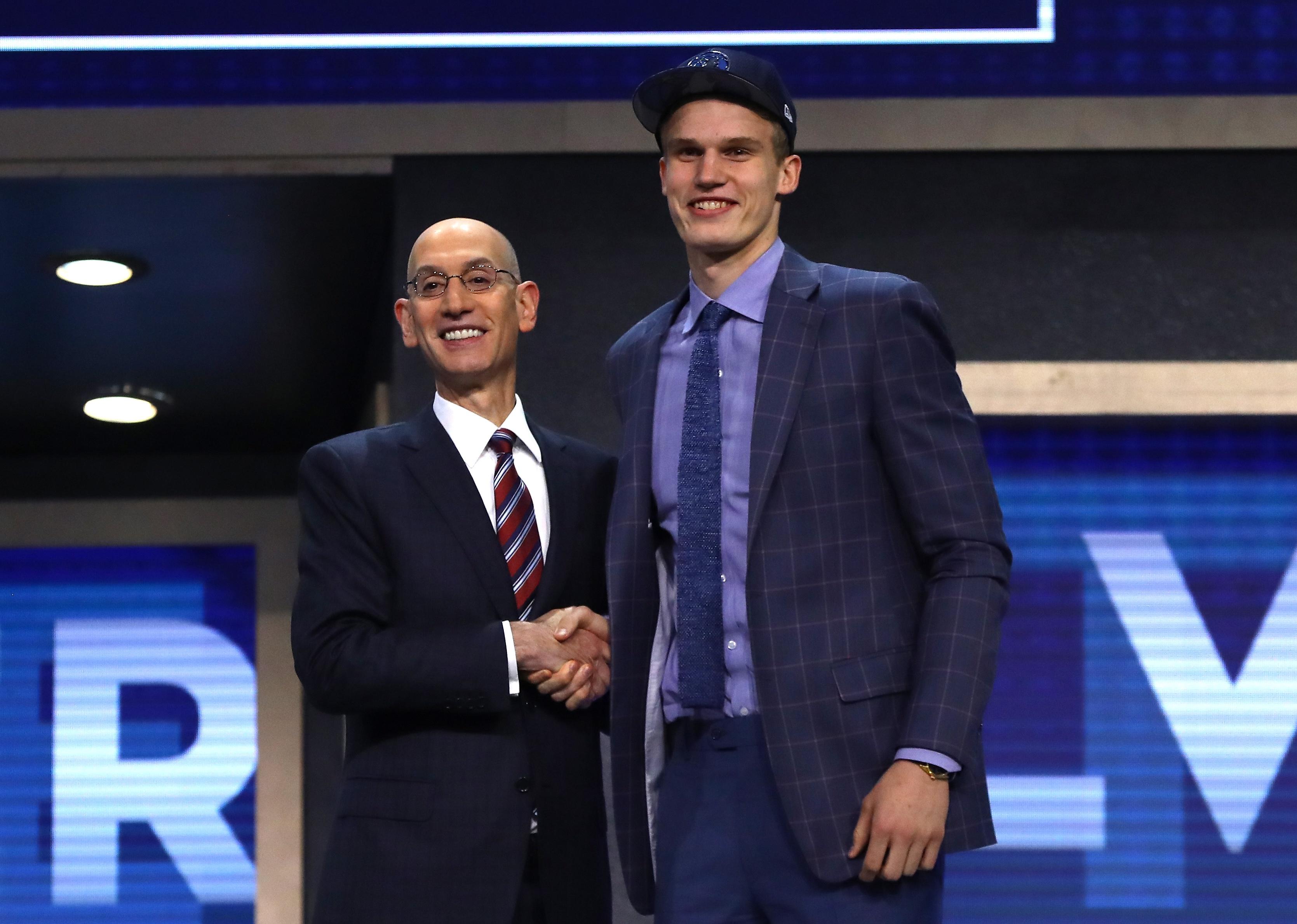 Lauri Markkanen on stage with NBA commissioner Adam Silver after being drafted.