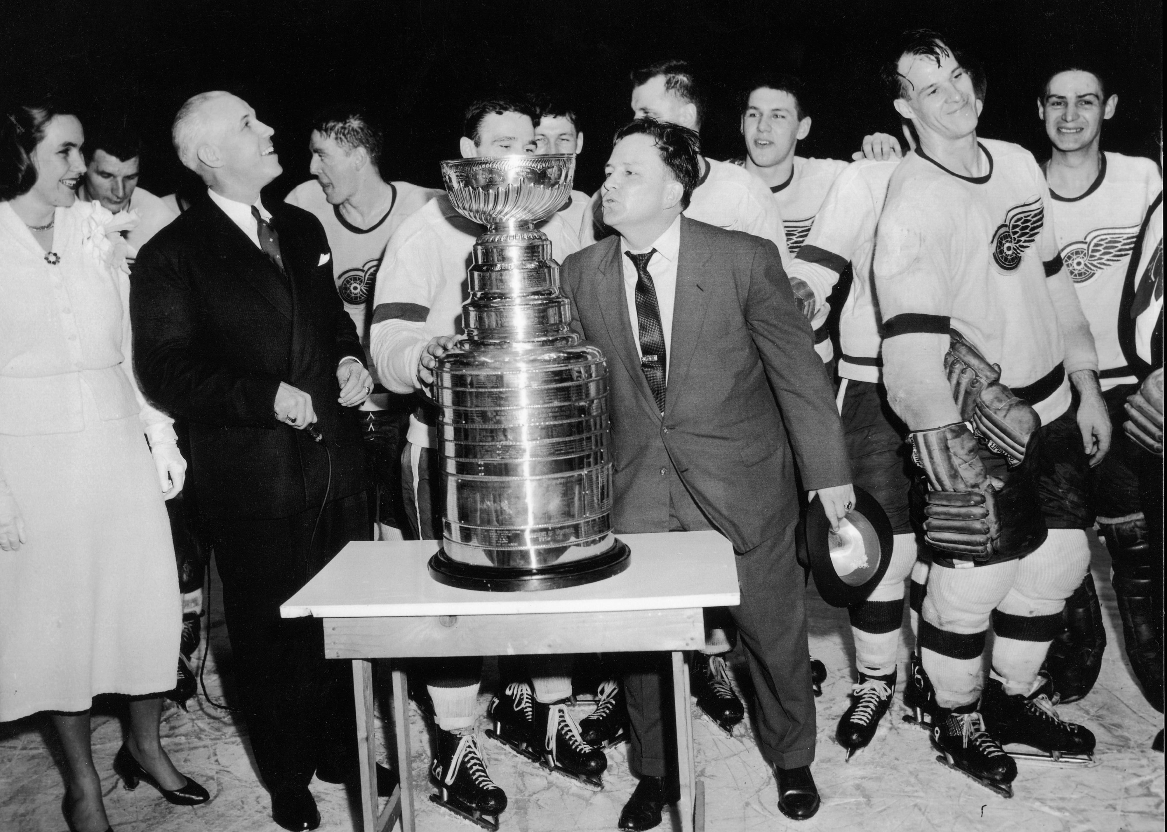 Head coach Jimmy Skinner of the Detroit Red Wings leans in to kiss the Stanley Cup trophy after his team won.
