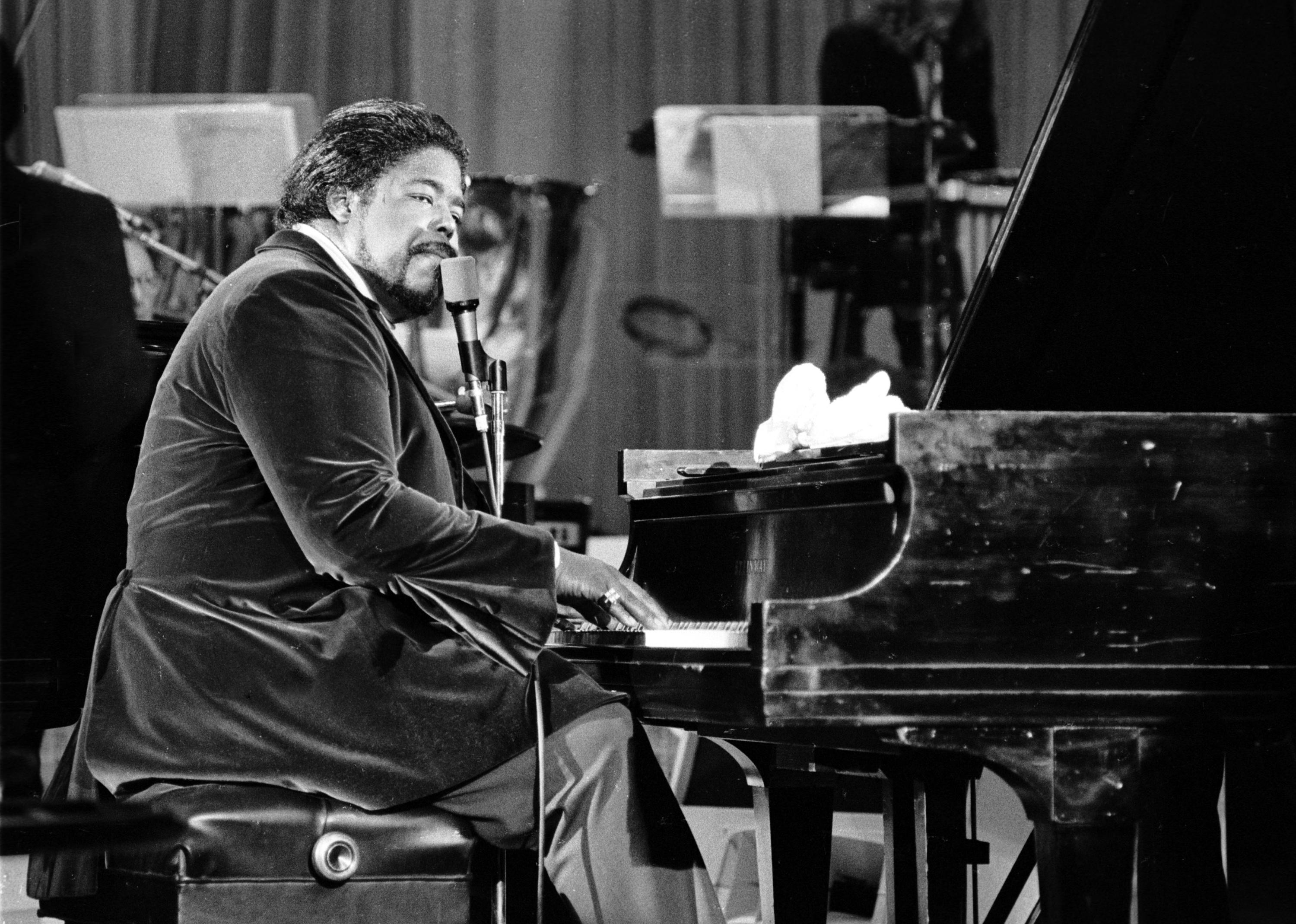 Barry White at a piano with microphone.