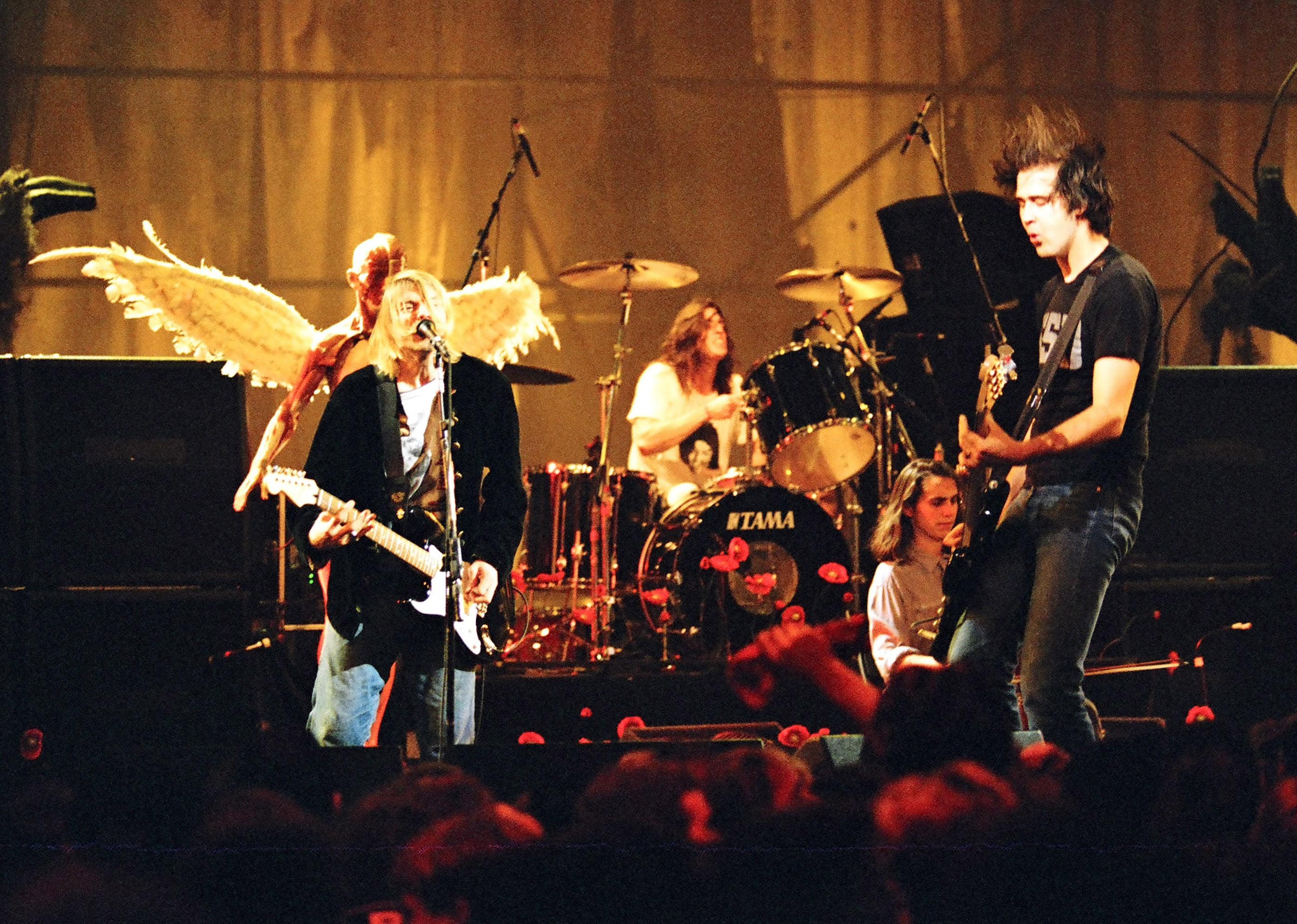 Kurt Cobain, Dave Grohl, and Krist Novoselic of Nirvana performing onstage.