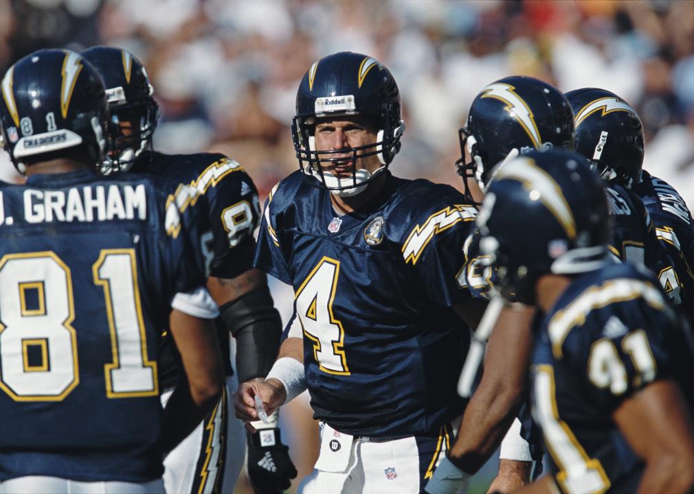 Jim Harbaugh of the Chargers talks to his offensive line in a huddle.