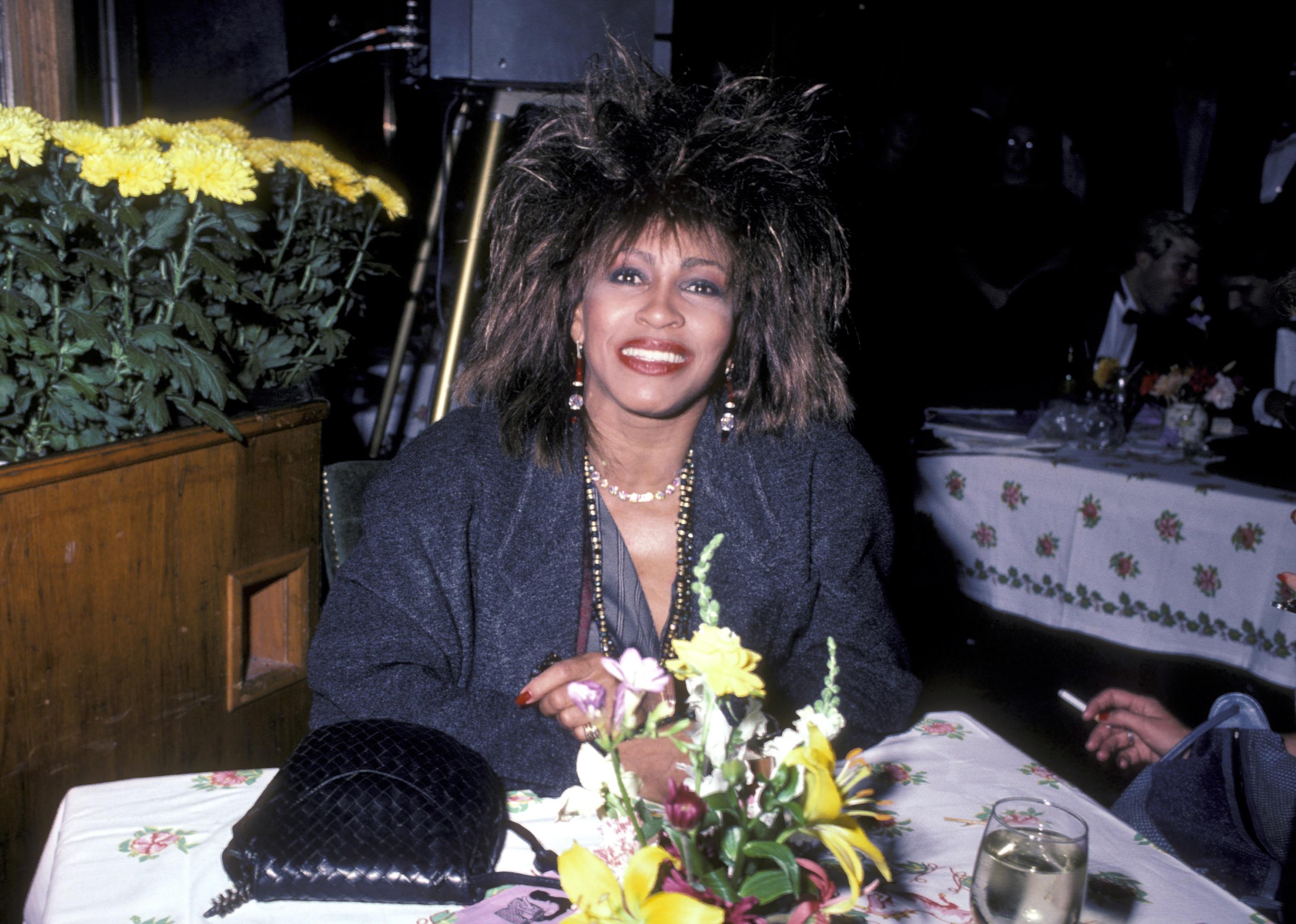 Tina Turner at a table at an after party for the 1984 MTV Video Music Awards.