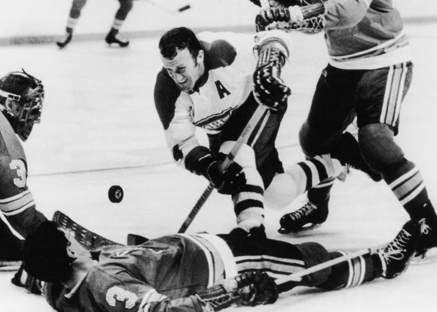 Claude Provost goes for the puck amid downed St. Louis Blues players