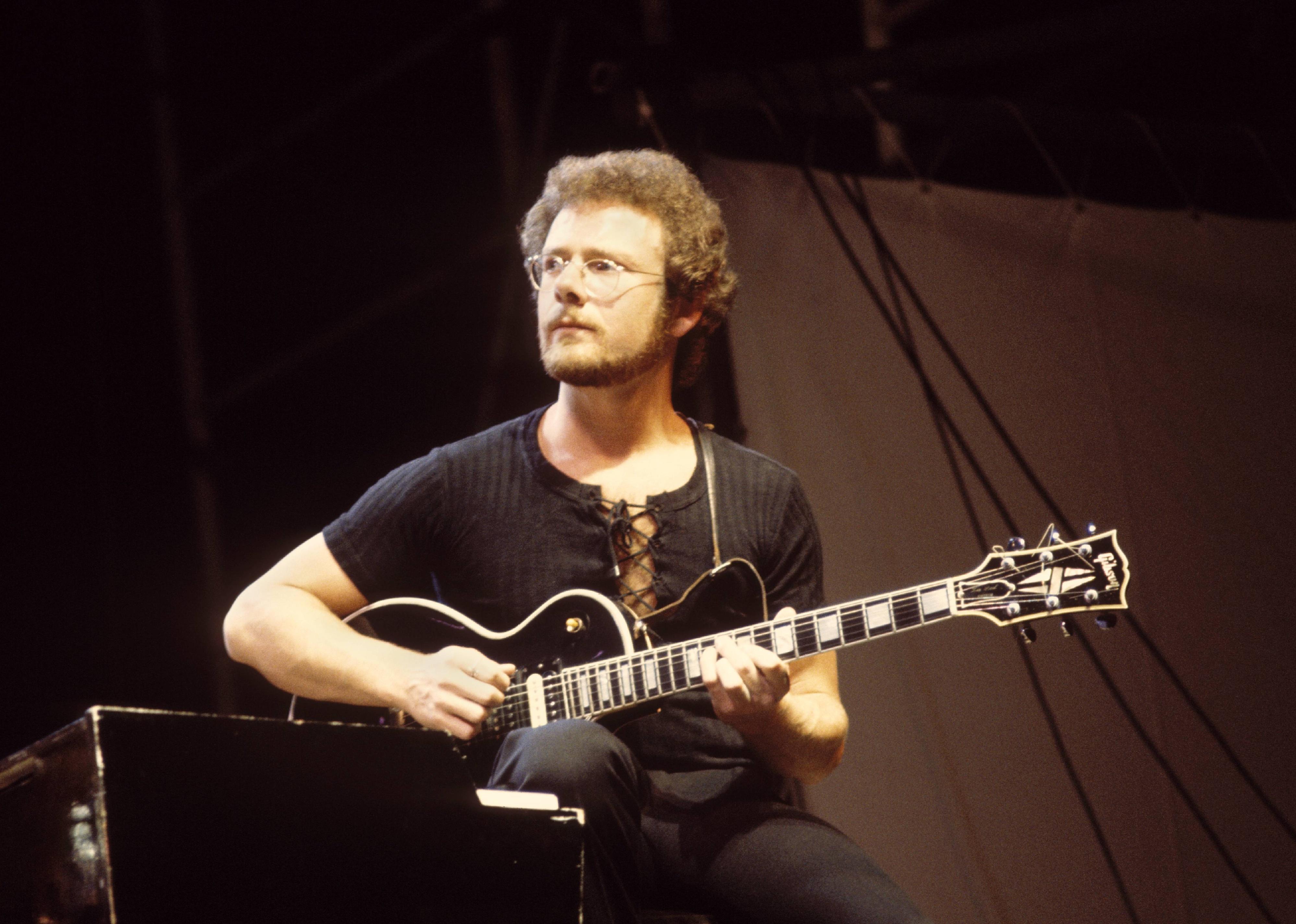 Robert Fripp playing Gibson Les Paul guitar live on stage.