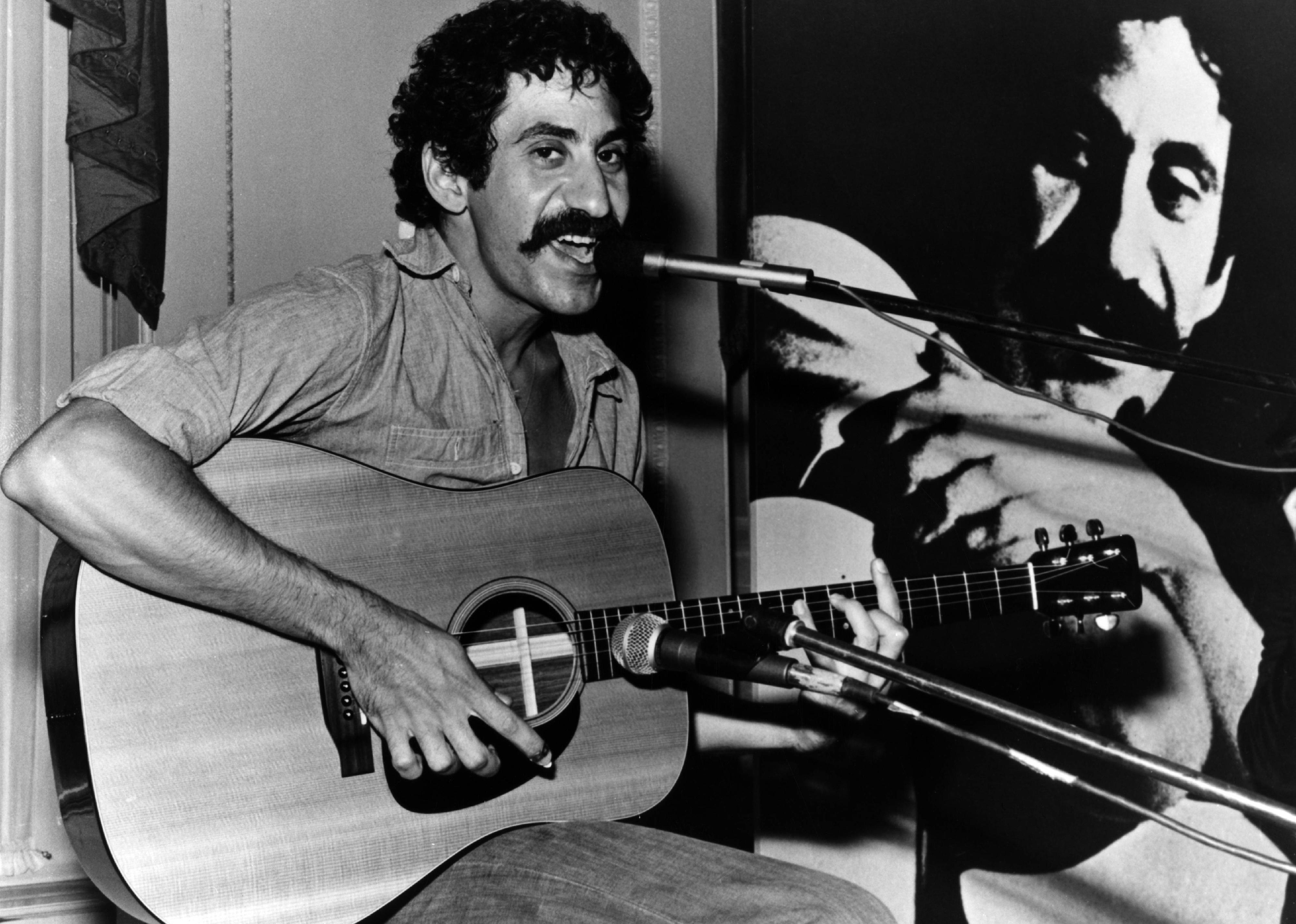 Jim Croce sitting with guitar and mic.