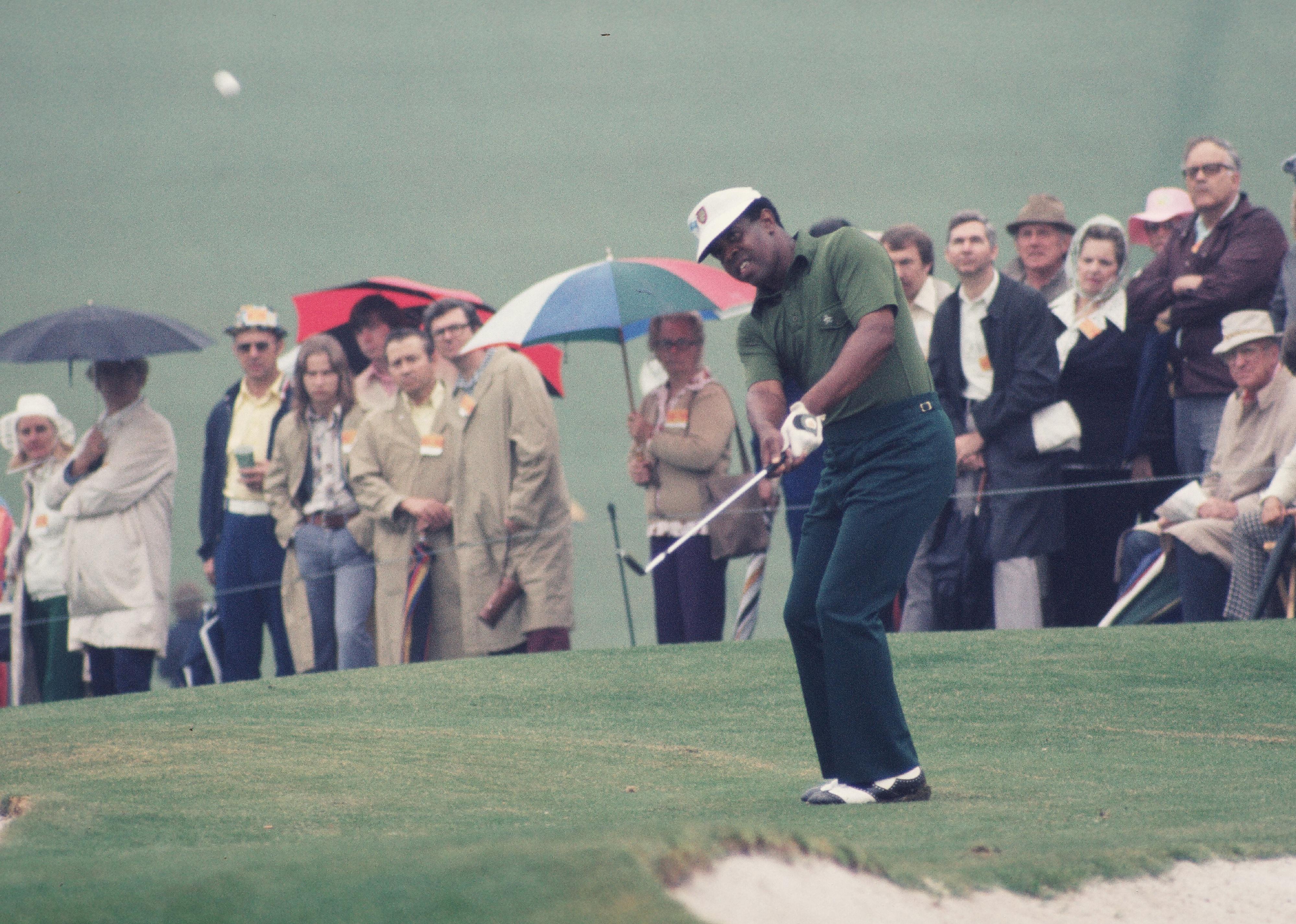Lee Elder watches his chip shot during the 1975 Masters Tournament.