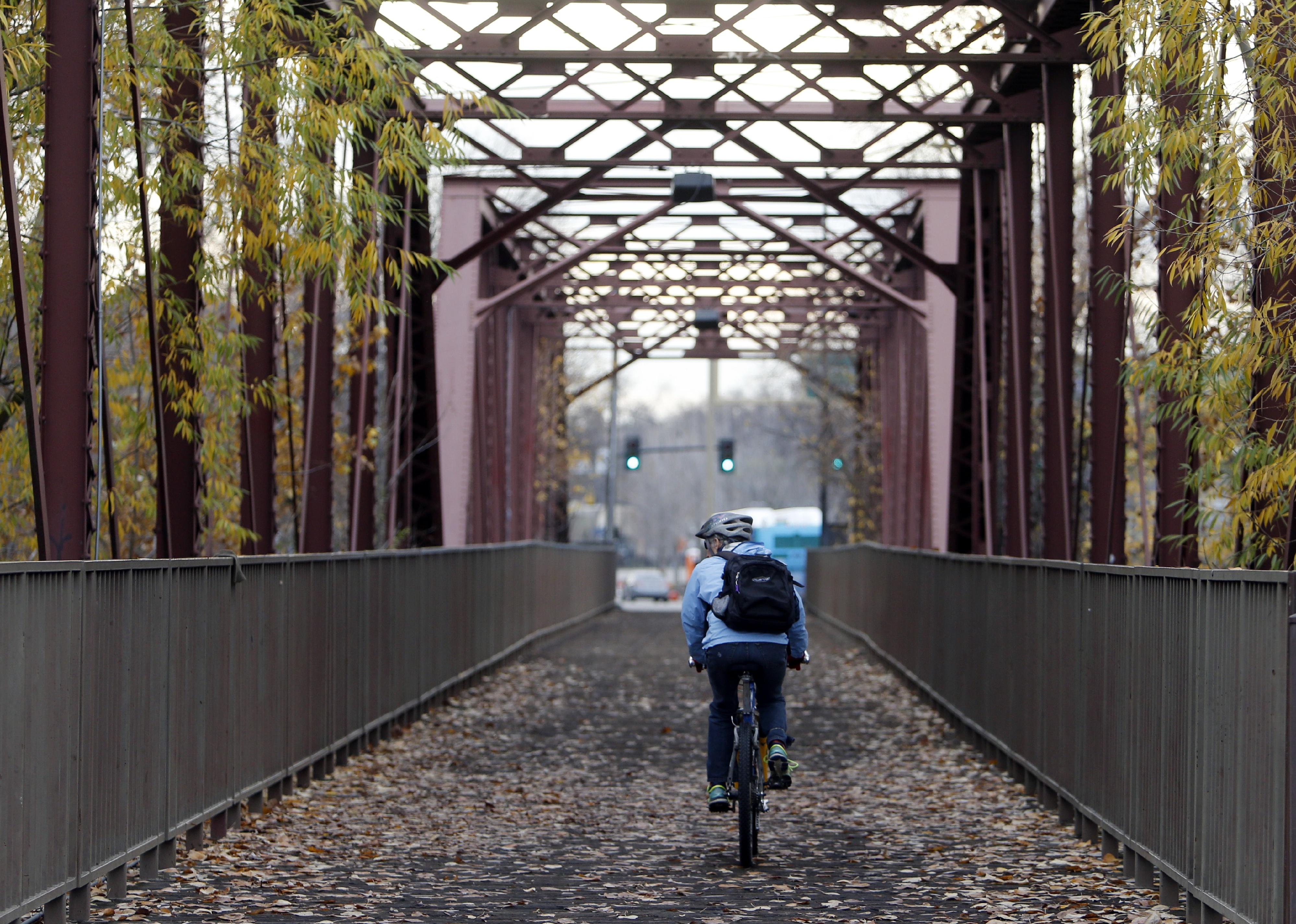 A cyclist rides over a former railroad bridge near Boise State University