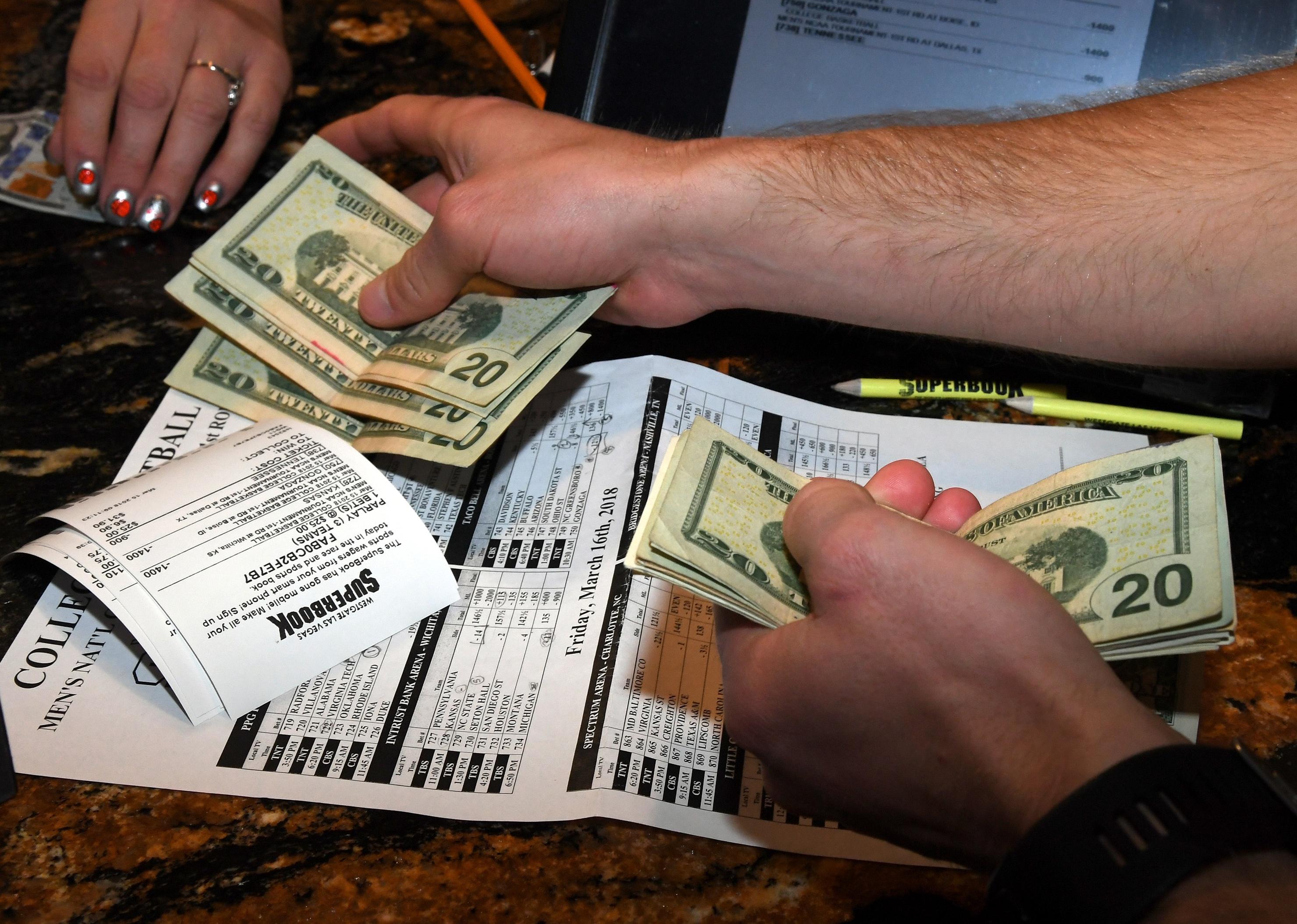 Man makes bets during a viewing party for the NCAA Men's College Basketball Tournament.