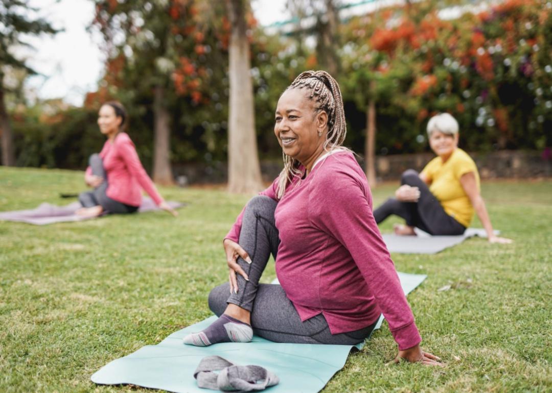 A person stretching on a yoga mat outside.