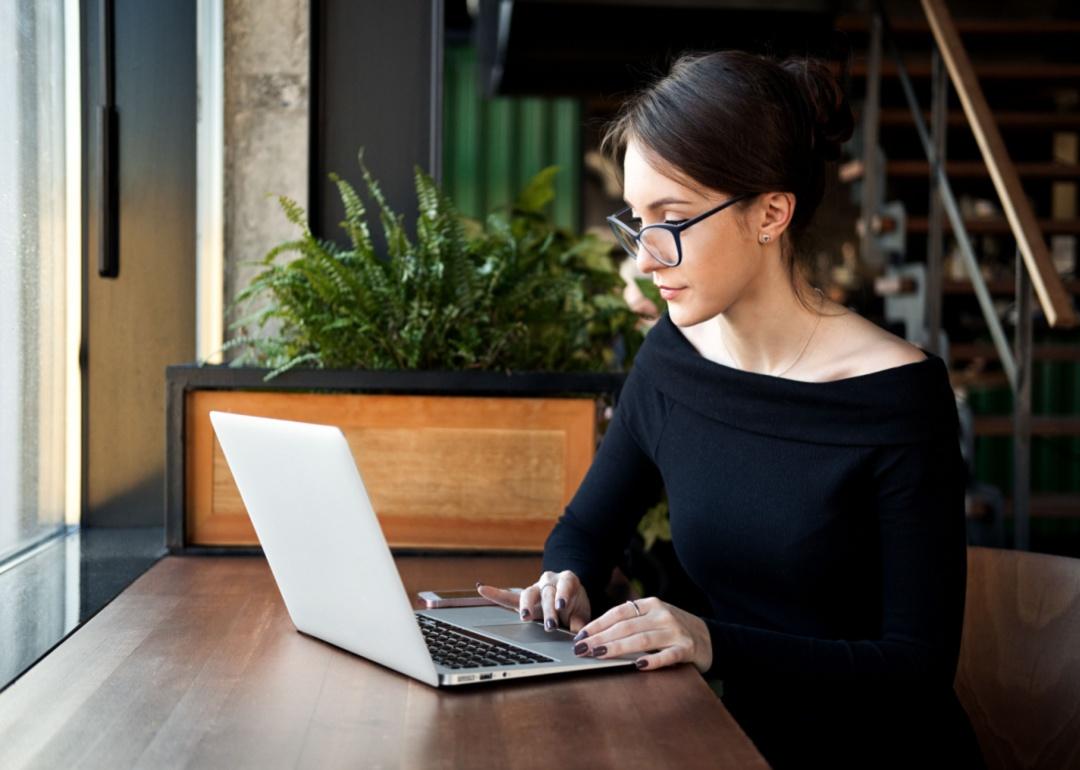 A person in black working at a laptop.