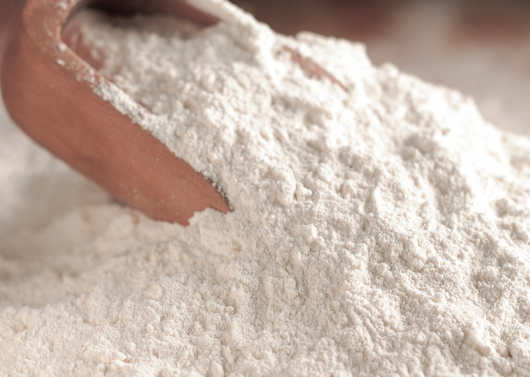 A wooden scoop in white flour.