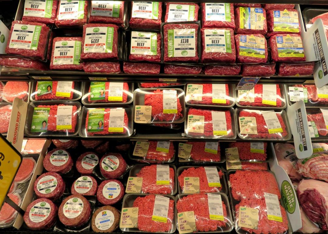 A grocery shelf filled with various ground beef packages.