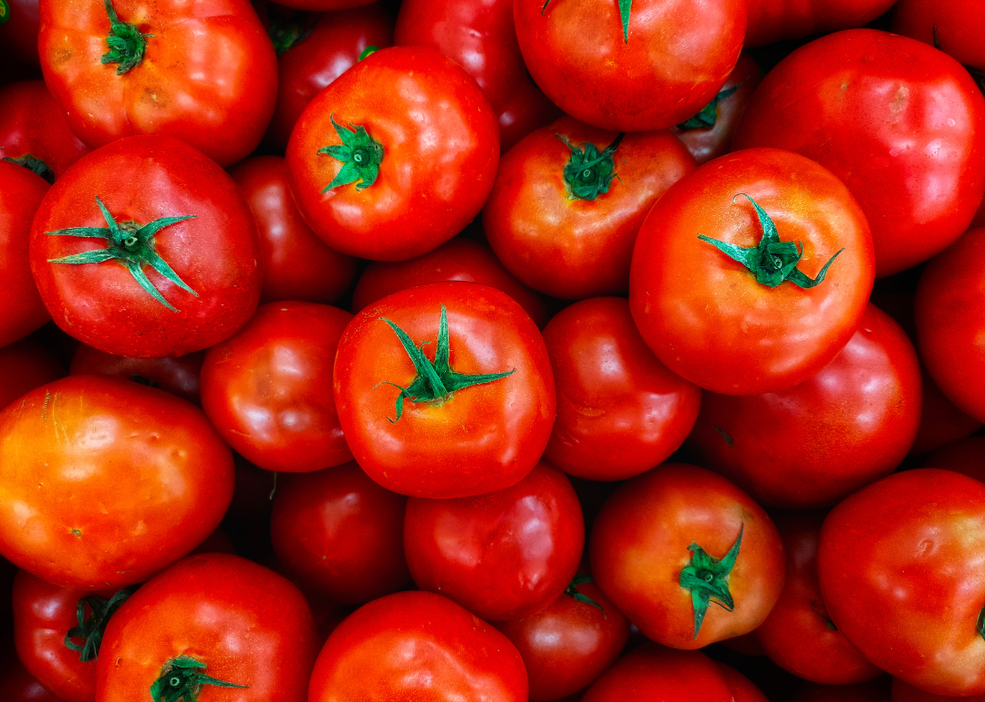 Bright red tomatoes with green tops.