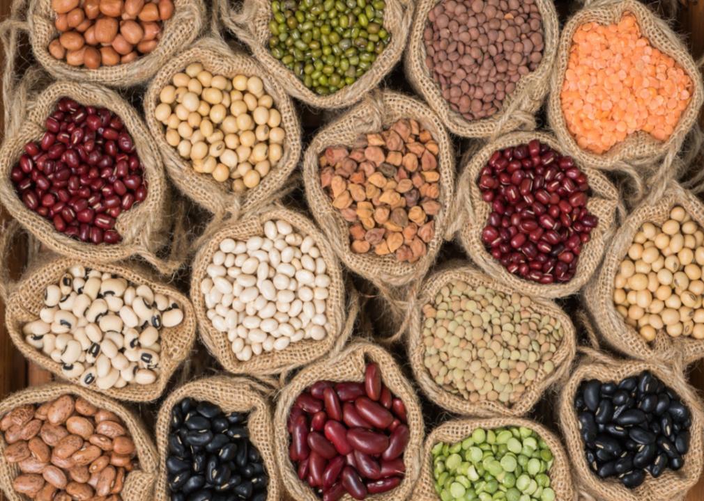 Various dried beans in burlap sacks.